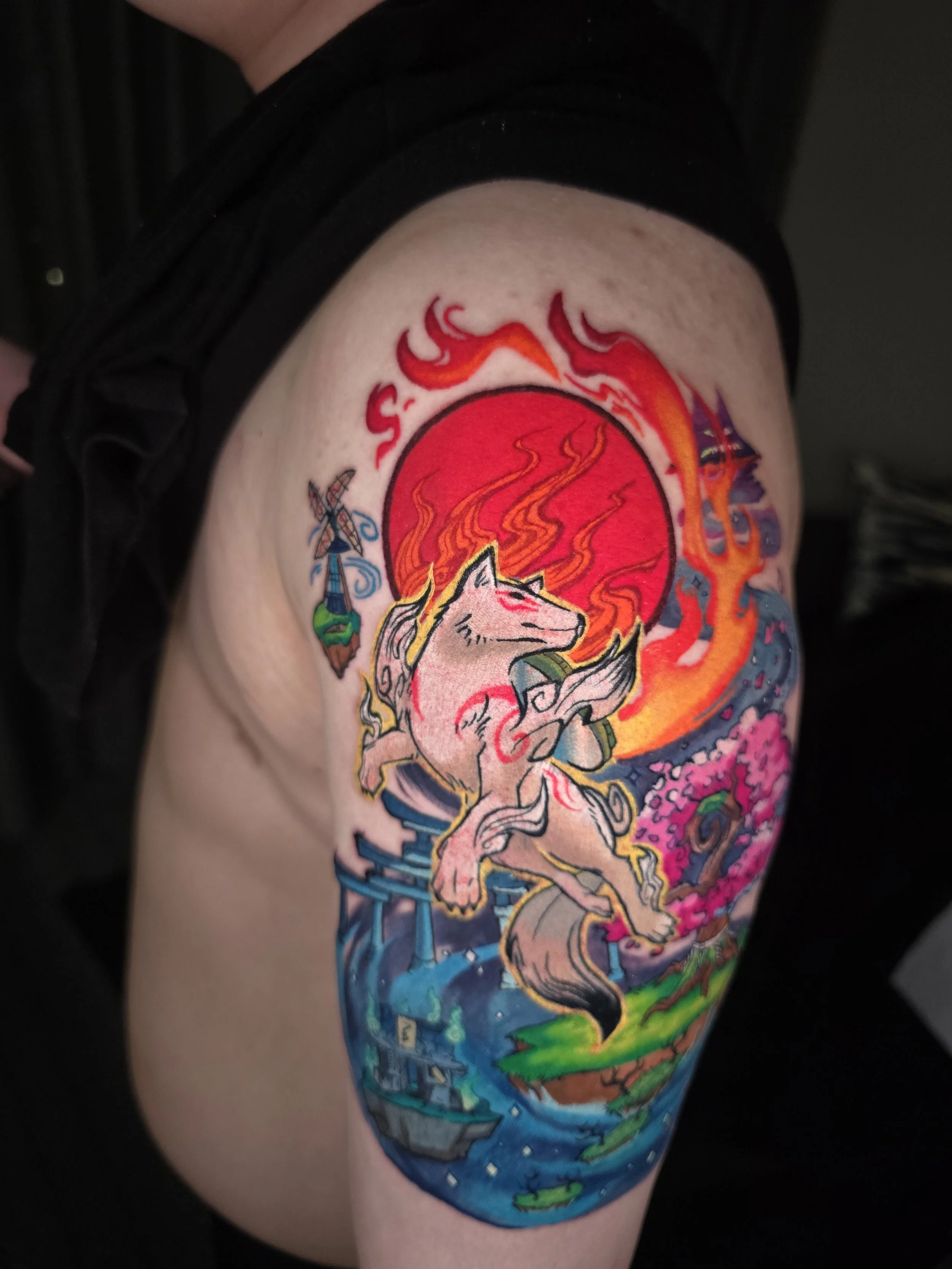 Colorful tattoo of a unicorn surrounded by flames and a rainbow, covering the upper thigh.