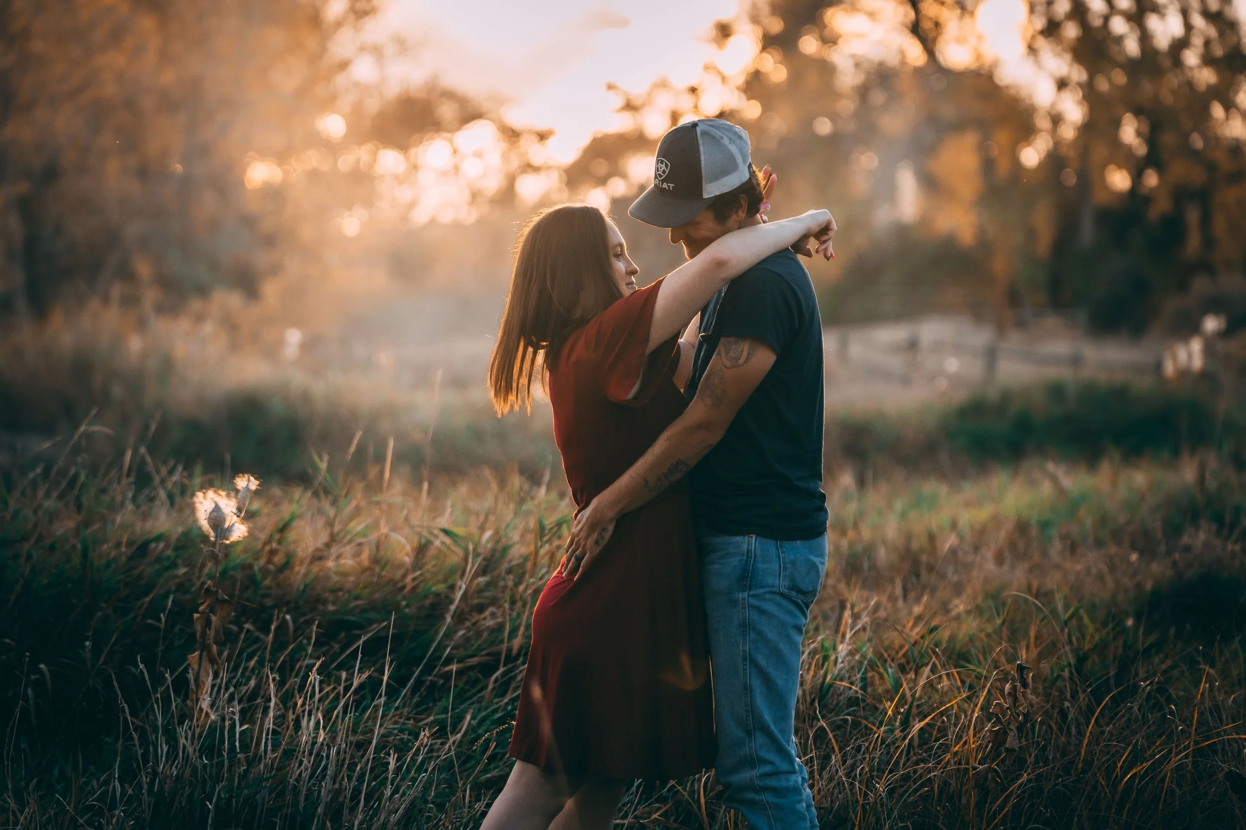 Couple embracing in a sunlit field at golden hour