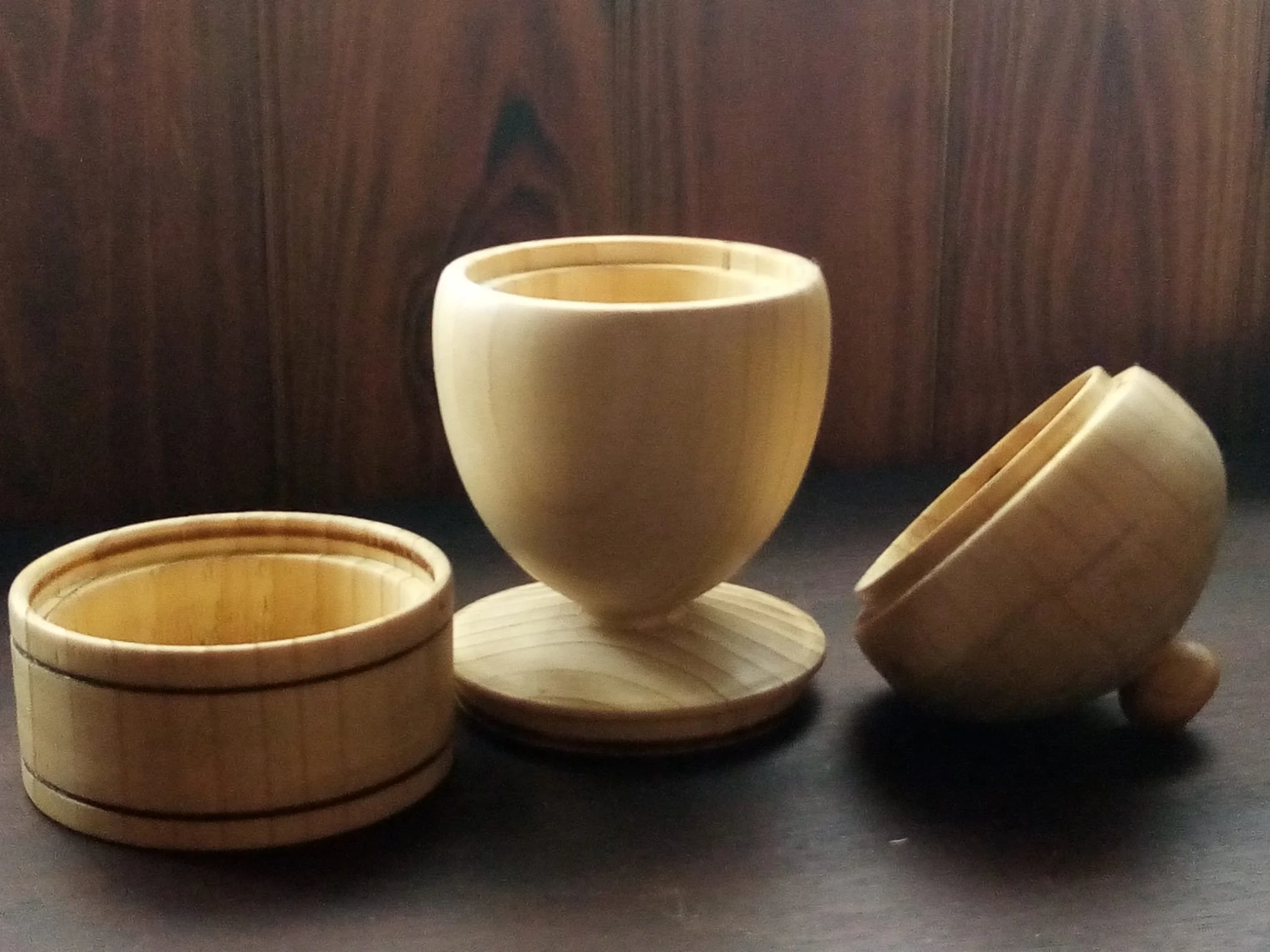 Joyero de madera clara en forma de bellota, con tapa rematada en un pequeño pomo y base cilíndrica con dos líneas oscuras abierto