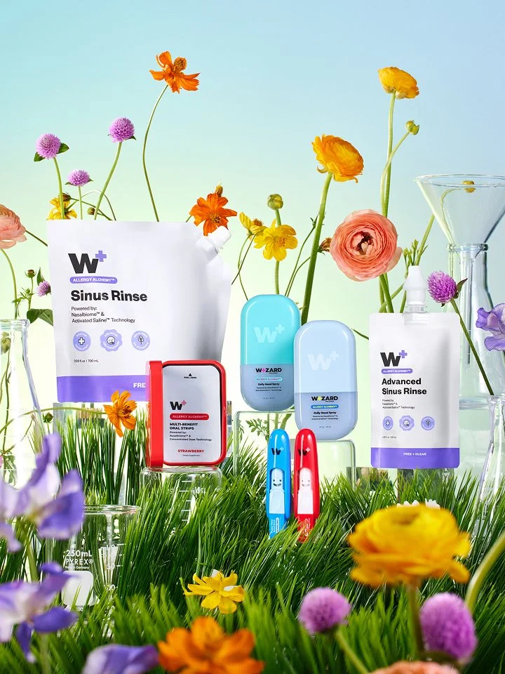 A floral and grass scene, with a set of Wizard Wellness packaging sitting on the grass.