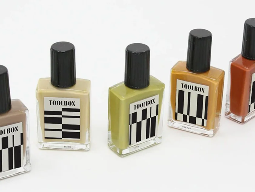 A set of nail polish bottles with Toolbox Men's Nail Care branding on the front label.
