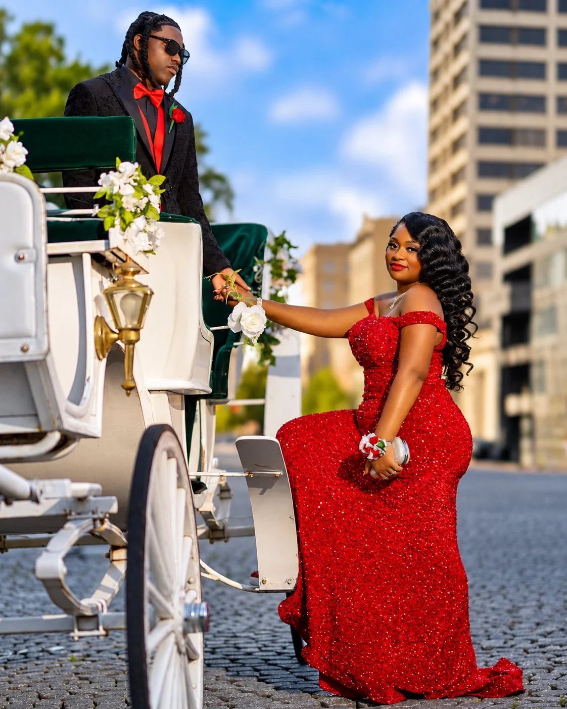 Prom couple in formalwear beside a white horse-drawn carriage, photographed by Pugh Logic Productions.
