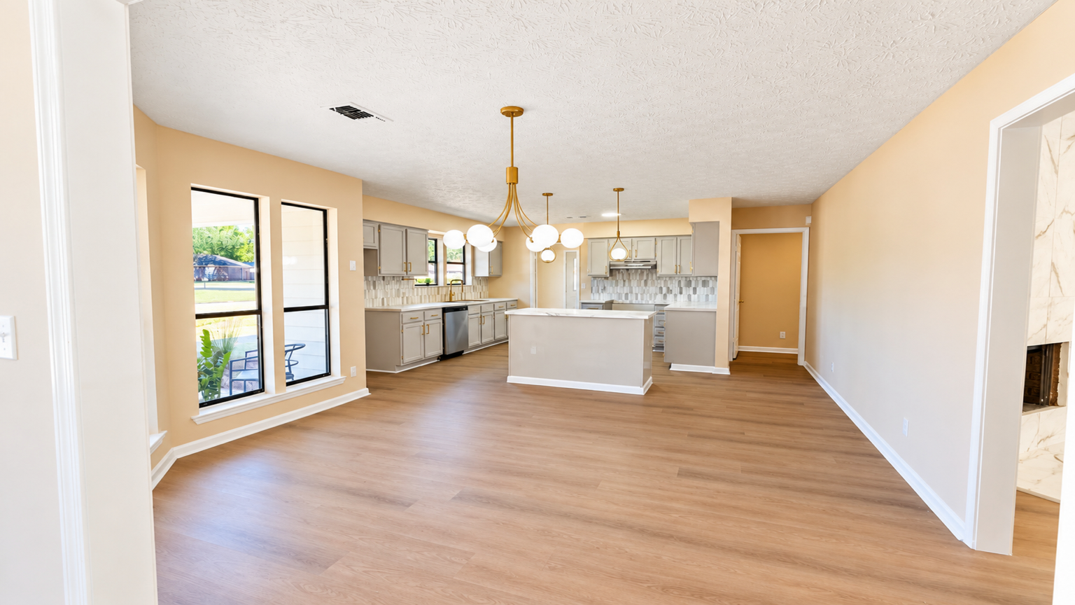 Bright wide-angle view of an open living space and kitchen, photographed by Pugh Logic Productions.