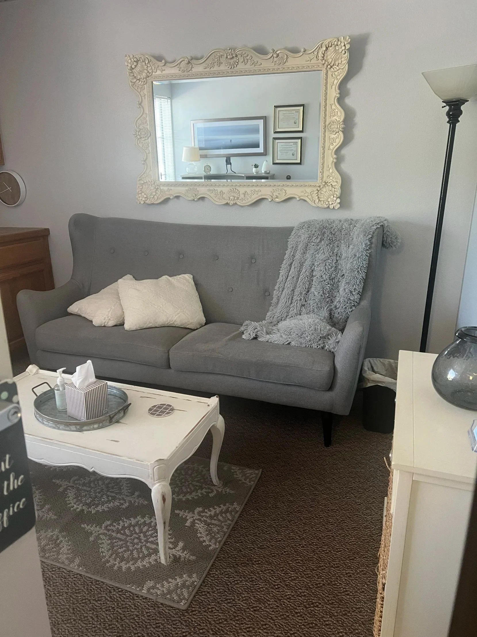 Counseling room at Safe Harbor Counseling Center in Old Town Temecula, with a gray sofa, a cozy throw and a white framed mirror