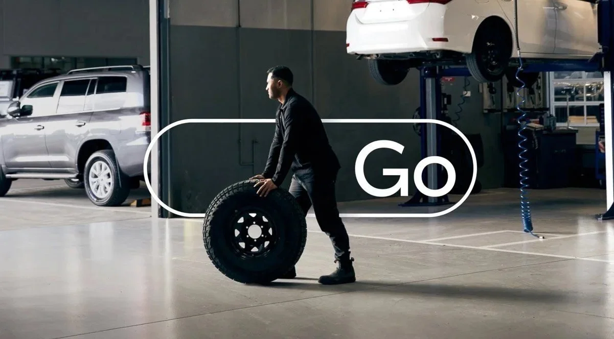 Toyota Go: a mechanic with a tyre in a service centre