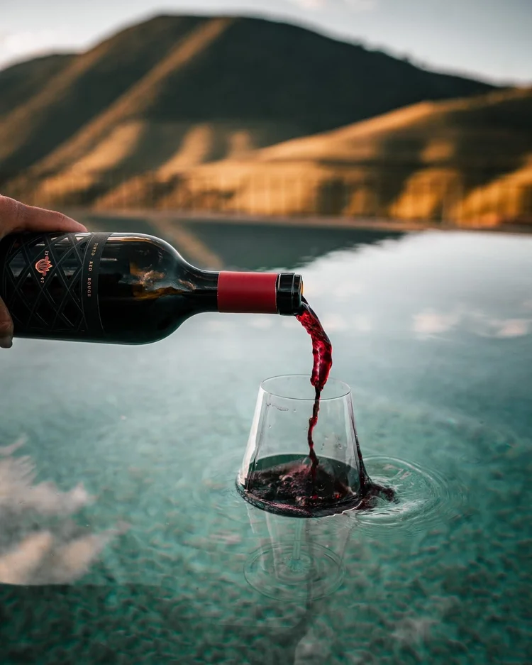 Red wine being poured into a glass, single bottle feature by wine.davide