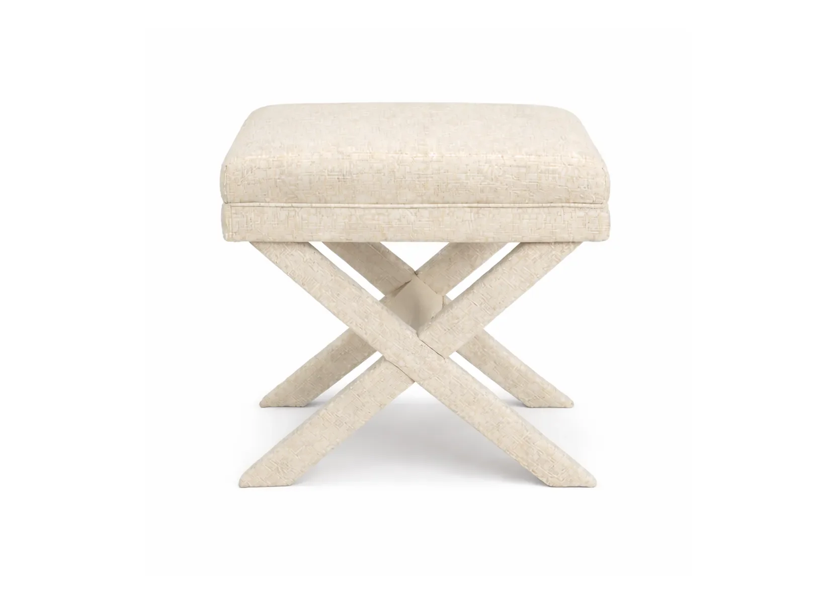 A cream-colored upholstered stool with a cushioned top and wooden X-shaped legs.