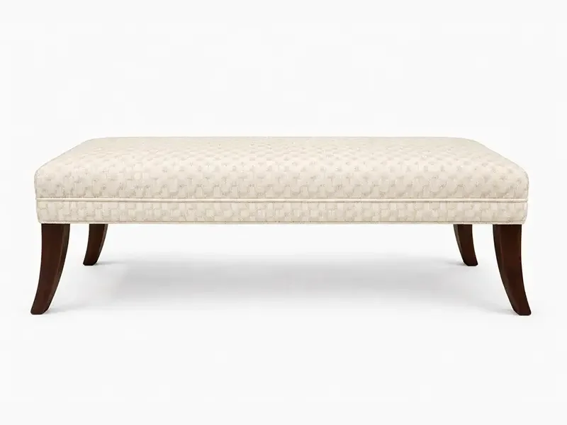 Elegant cream-colored upholstered bench with wooden legs against a white background.
