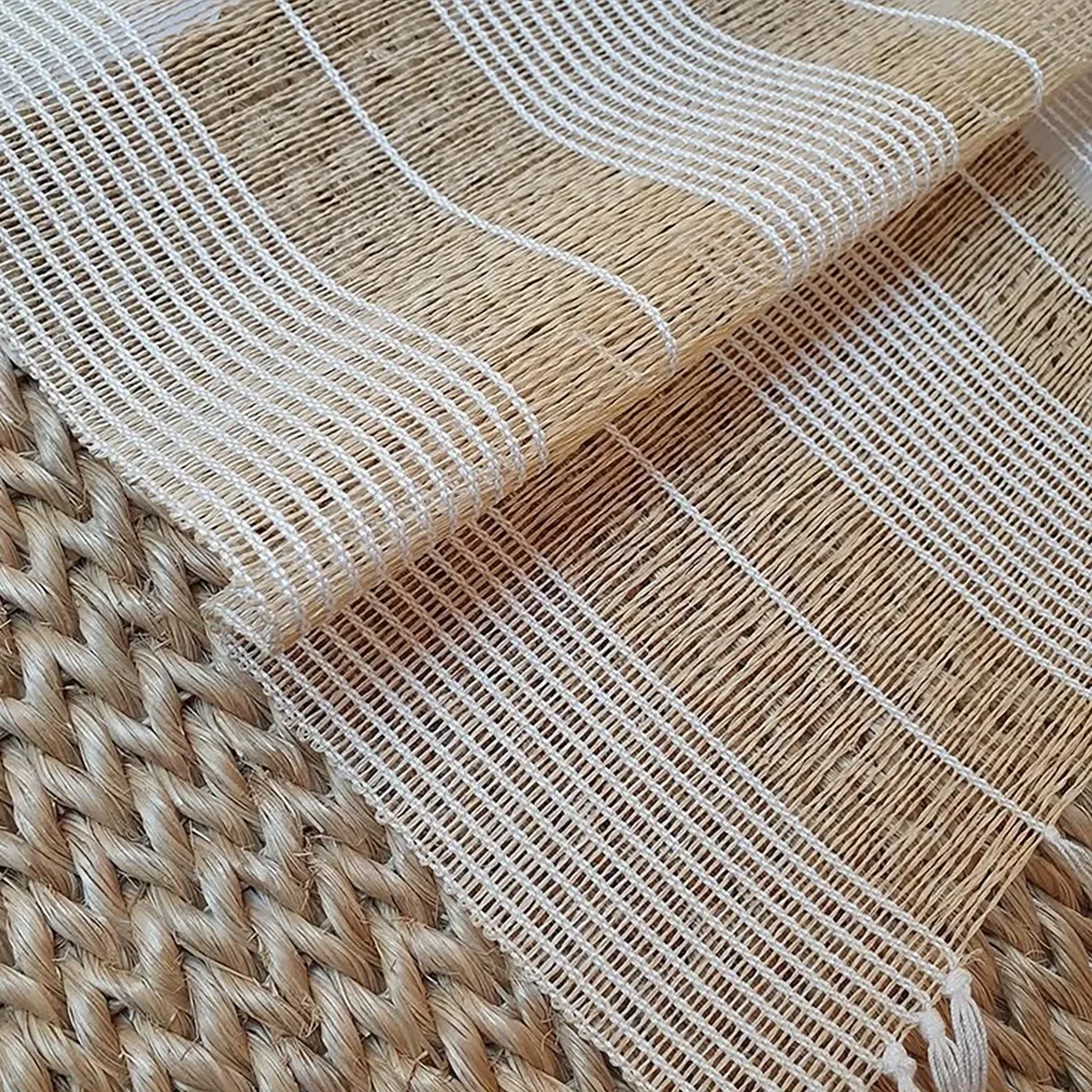 Close-up of woven fabric with striped patterns on a wicker surface.