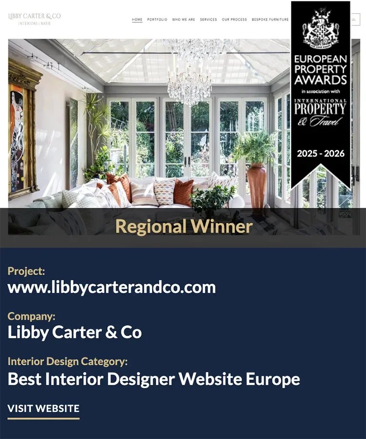 An award announcement for Libby Carter & Co, an interior design company, featuring a bright, elegant room with large windows, a chandelier, and a white sofa. The banner on indicates the company won the 'Best Design Website 2026'.