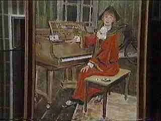 A woman in a red dress playing a piano in a room with wooden walls and a window.
