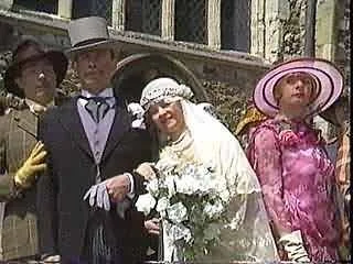 Four people dressed in vintage clothing, with a woman in a wedding dress and veil, standing outdoors