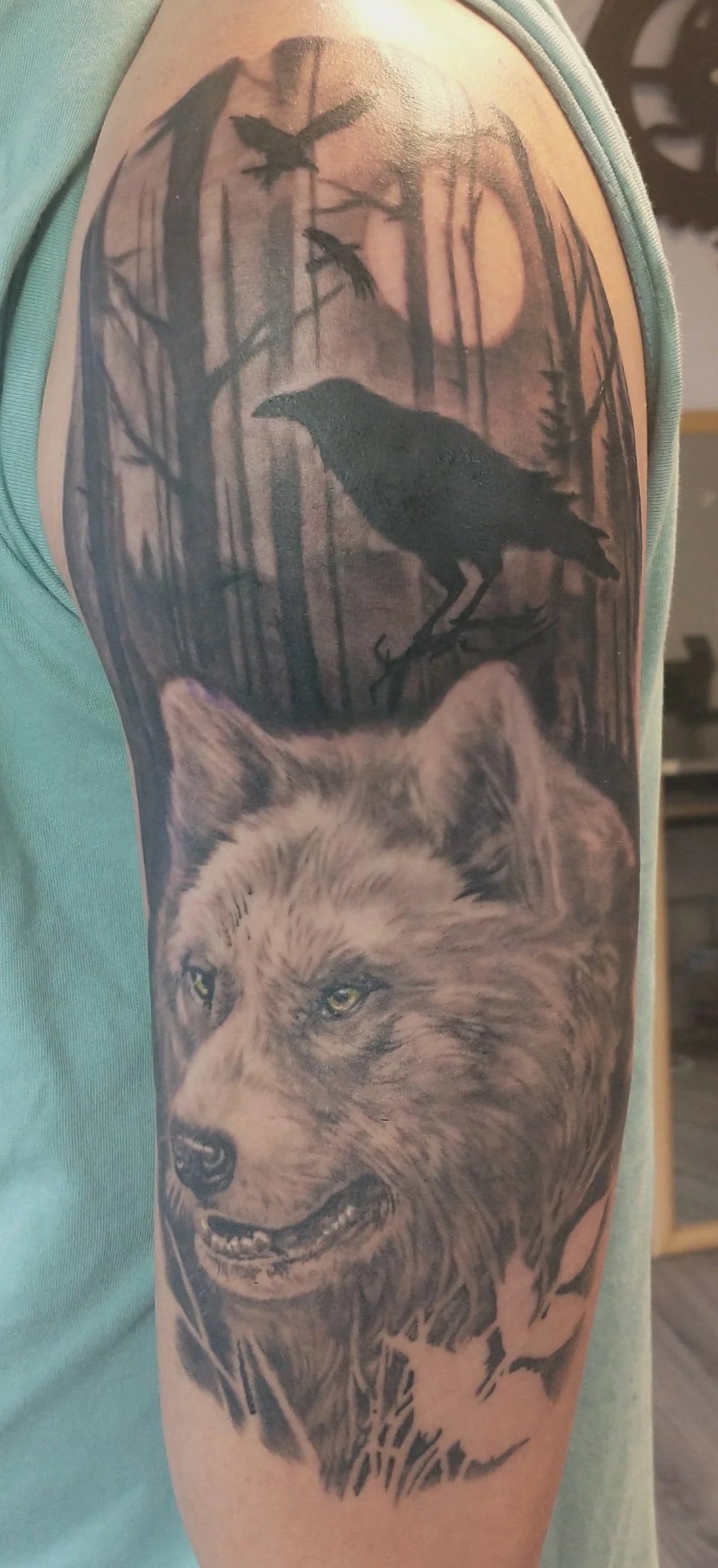 Detailed tattoo of a roaring lion beneath a moonlit forest with flying ravens