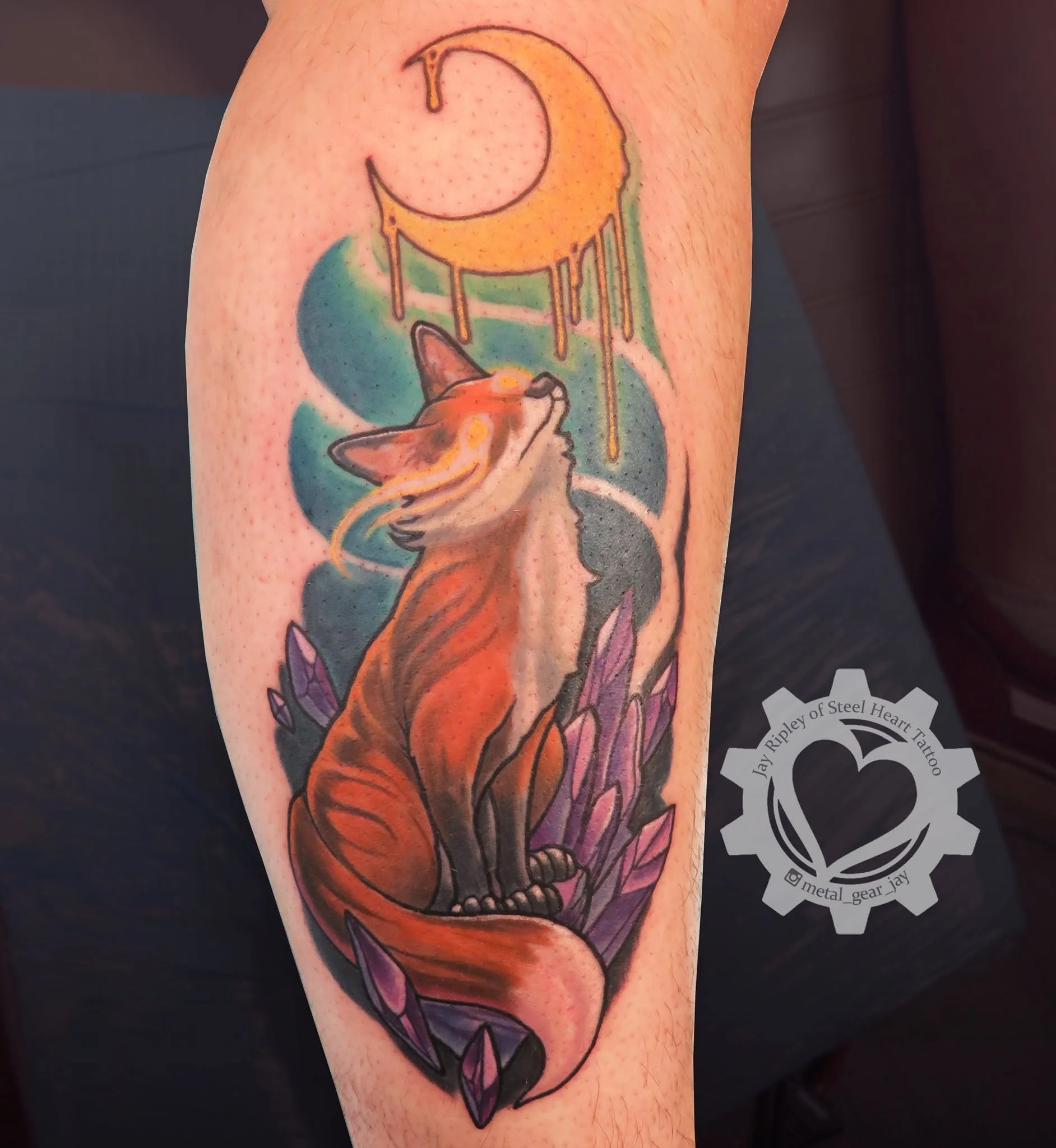 Colorful tattoo of a fox wearing a witch hat, surrounded by autumn leaves and purple crystals.