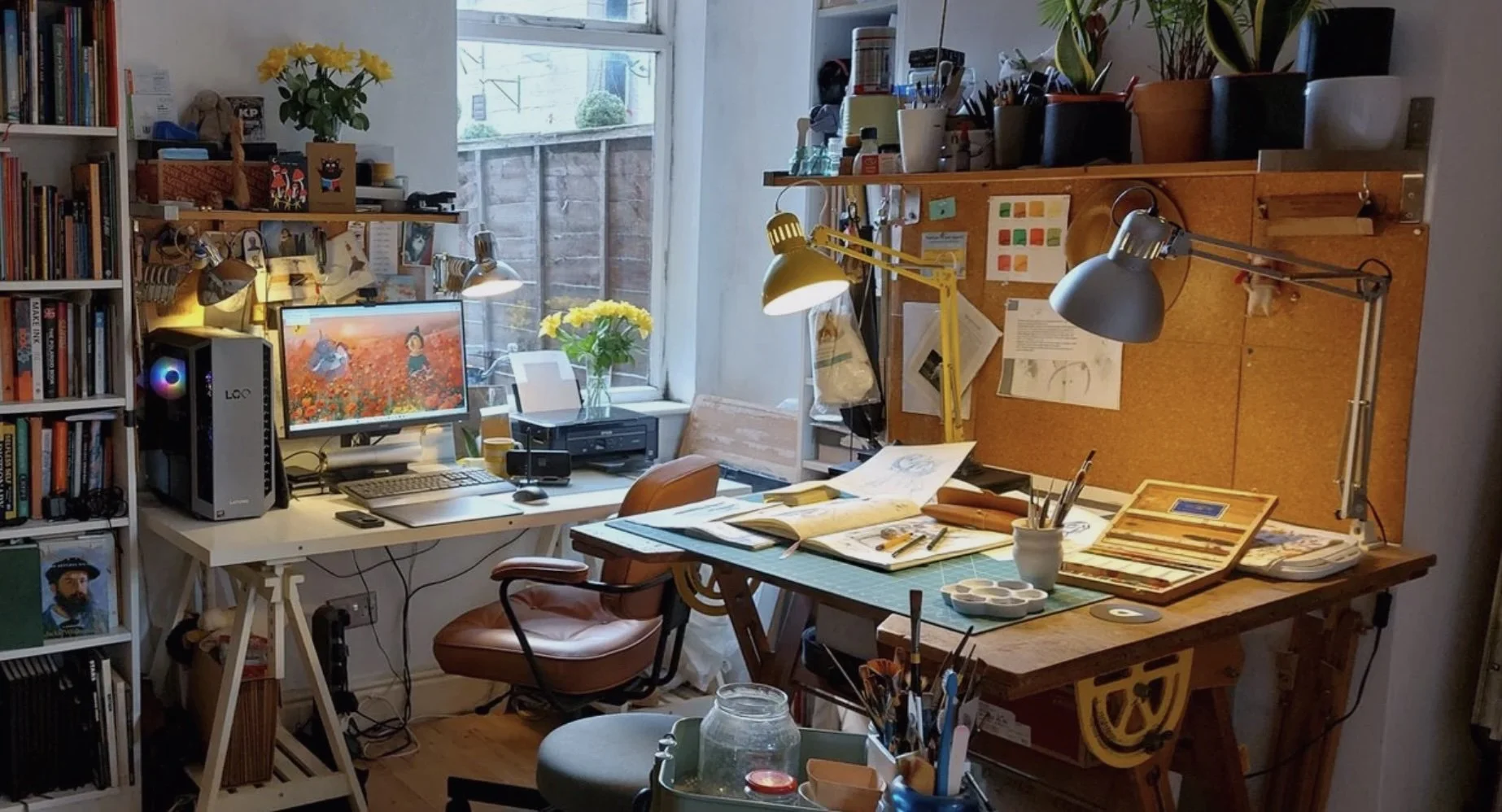 Cozy home art studio with drafting table, paints, brushes, lamps, computer, bookshelves, and houseplants