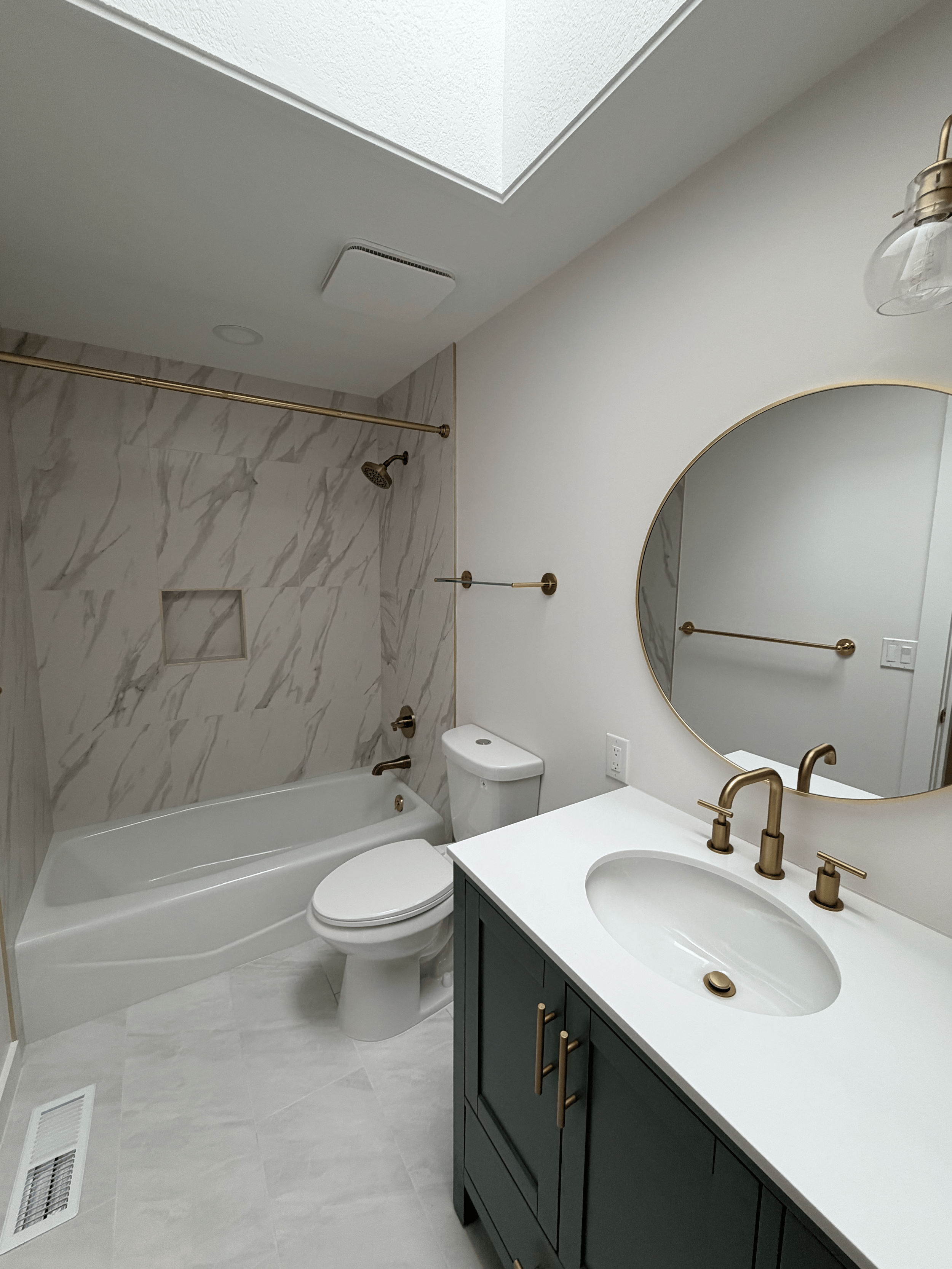 Sparkling bathroom with green vanity and gold fixtures