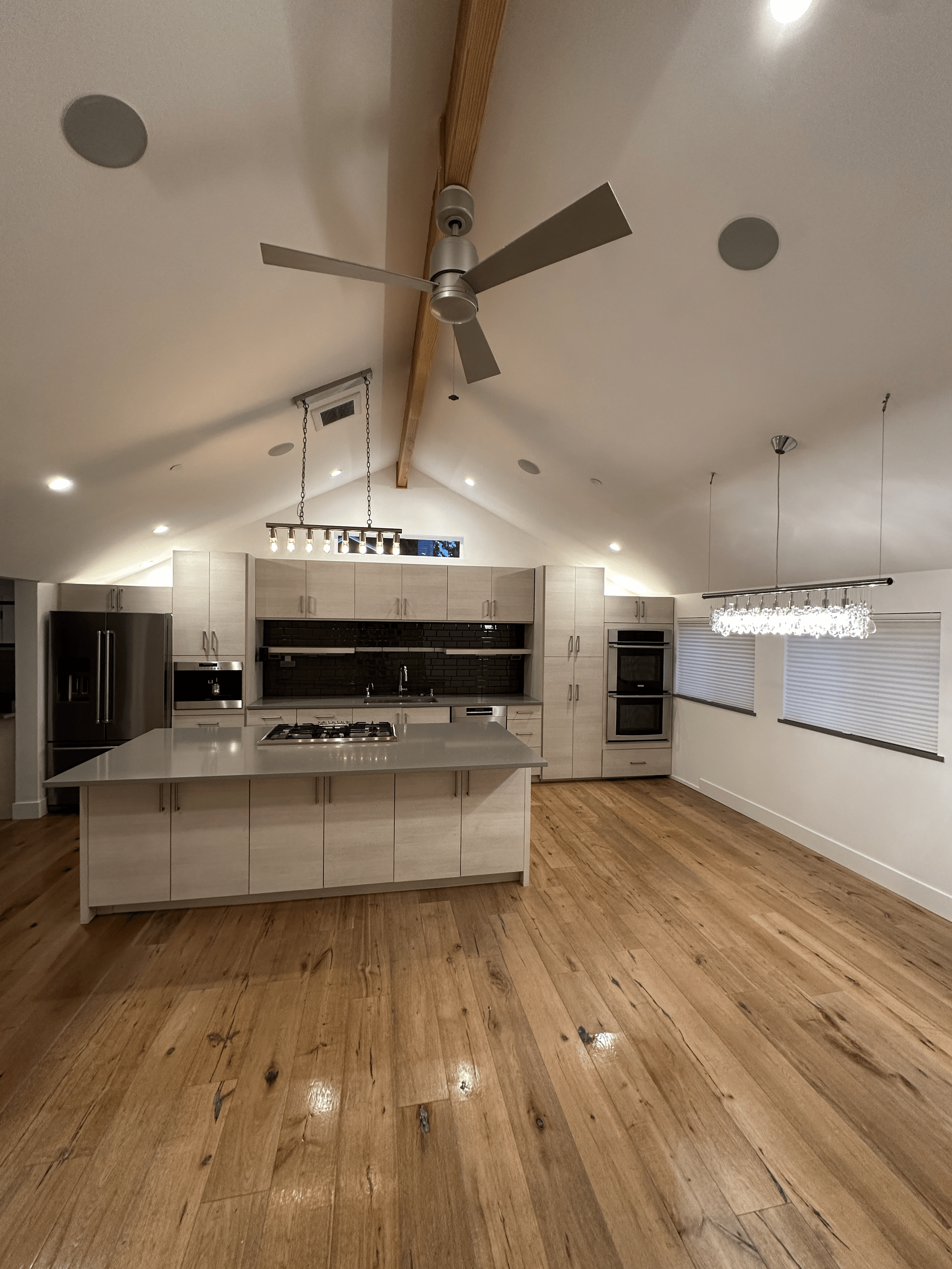 Bright, freshly cleaned kitchen with vaulted ceiling and wood floors
