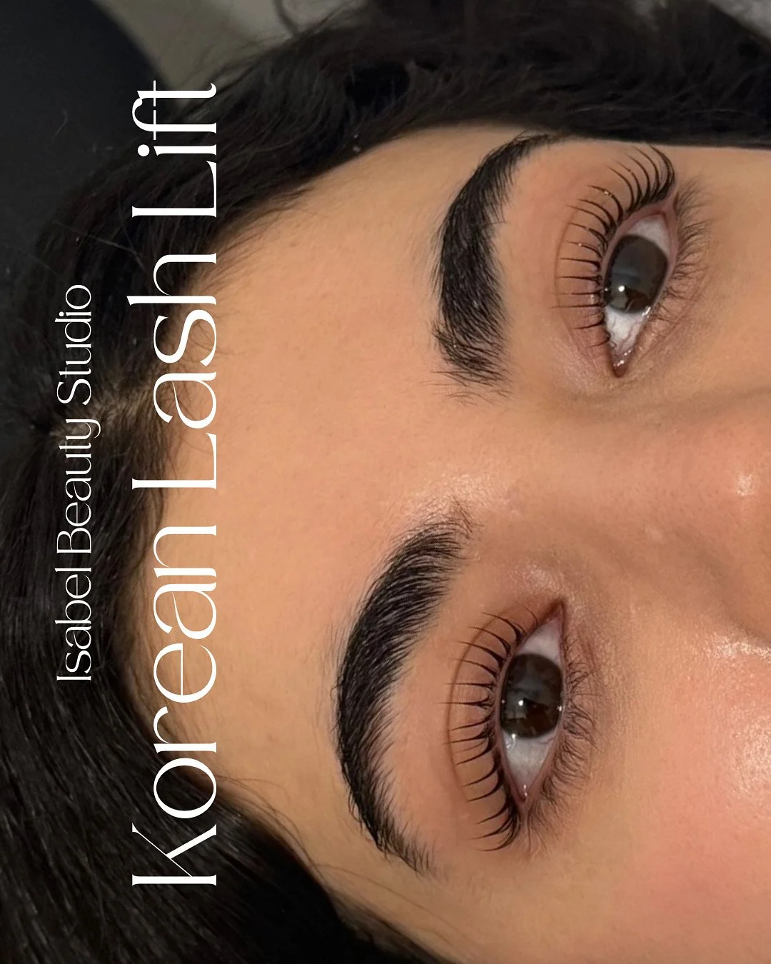 Close-up of a woman showcasing dramatic eyelash extensions and defined eyebrows at Isabel Beauty Studio.