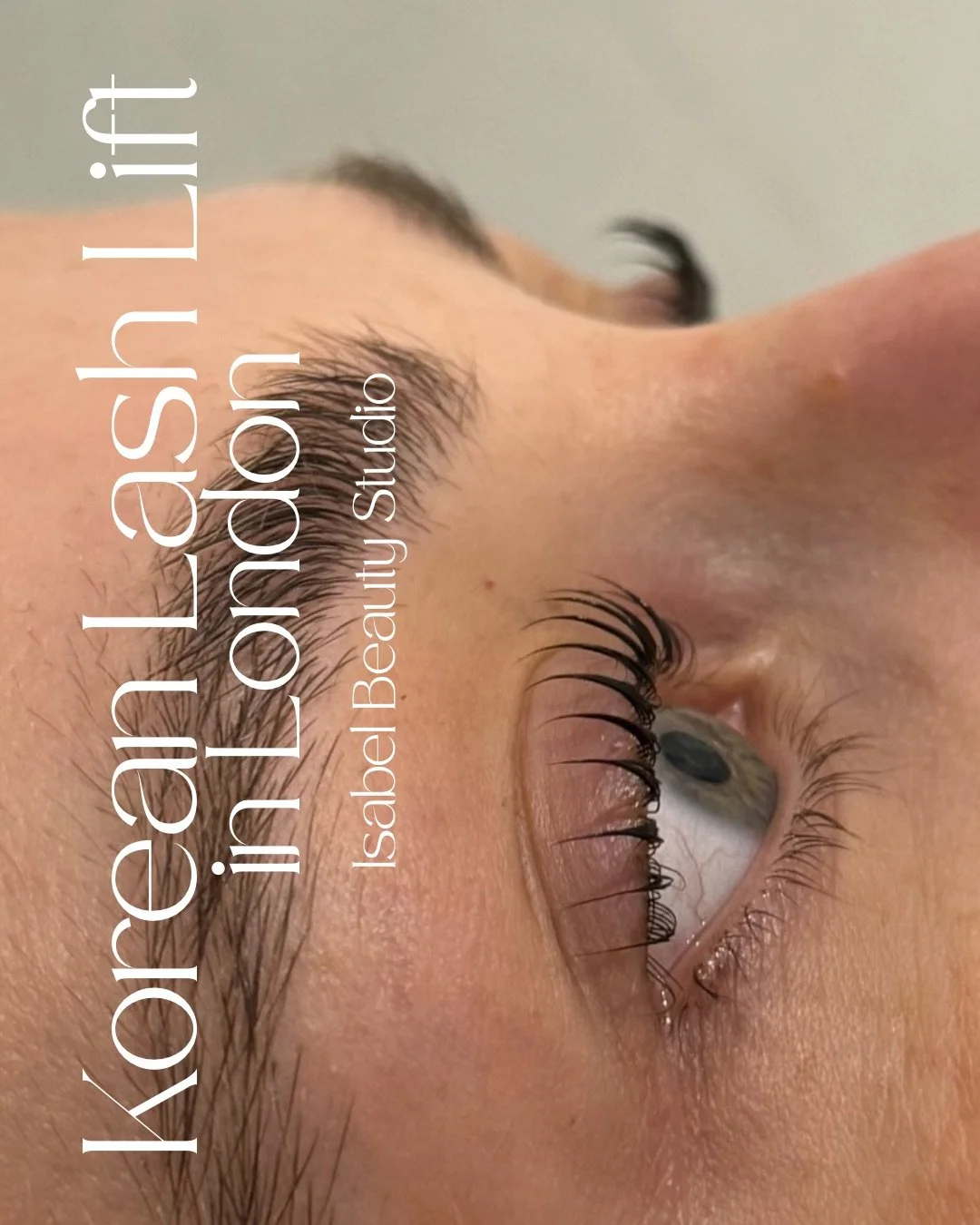 Close-up of a client’s eye with long, curled eyelash extensions and groomed eyebrow at a beauty studio