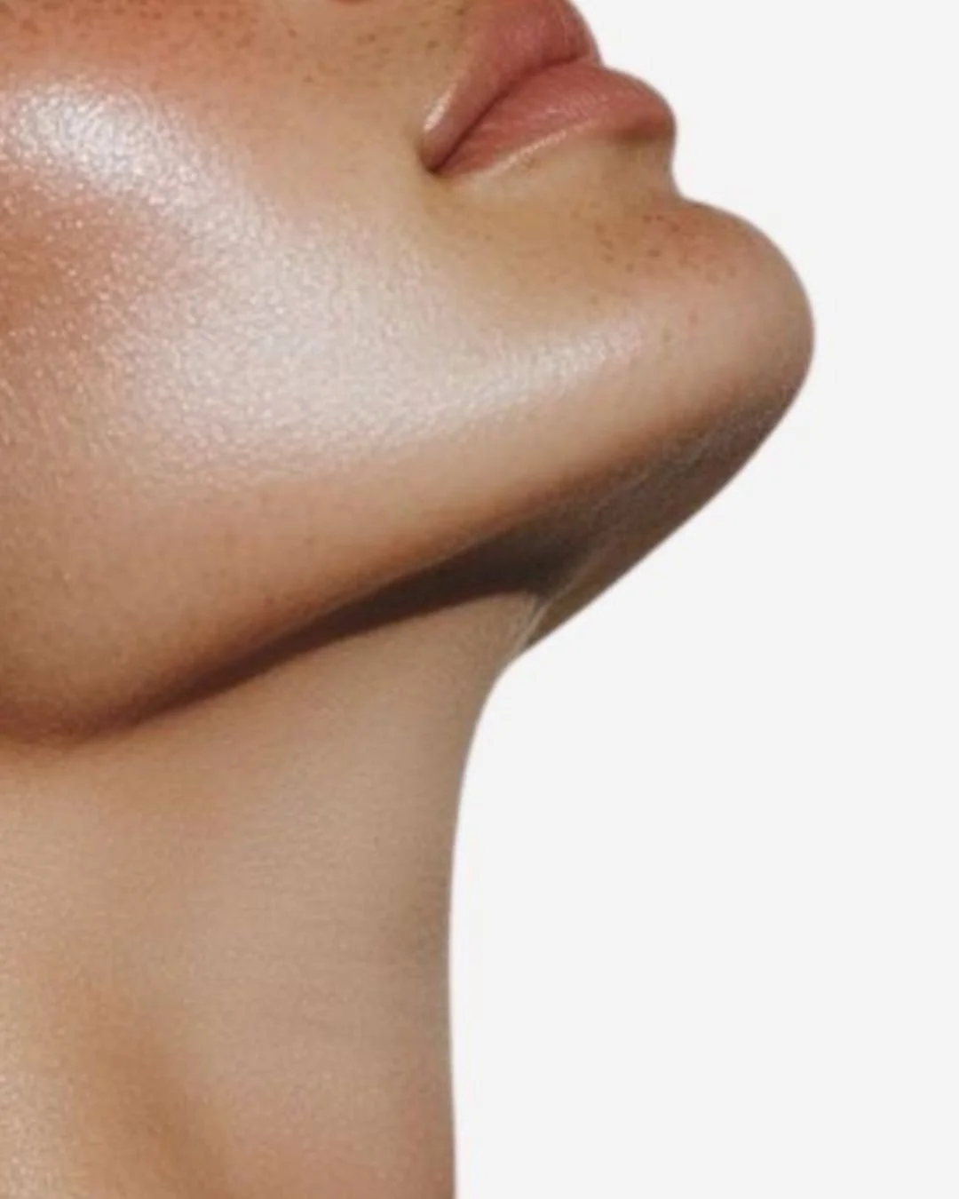 Close-up side profile of a person's chin, jawline, and lips against a white background