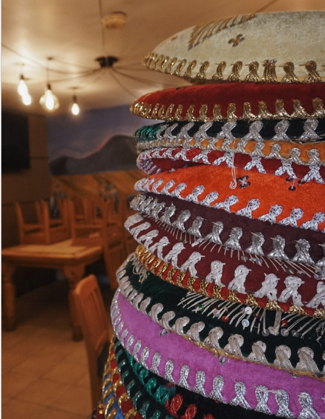 Close-up of colorful embroidered textile rolls with metallic trim in a warmly lit restaurant