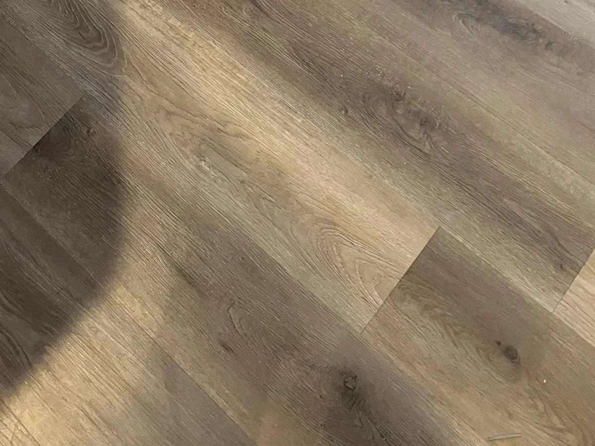Close-up photo of a wooden floor with a shadow cast on it.