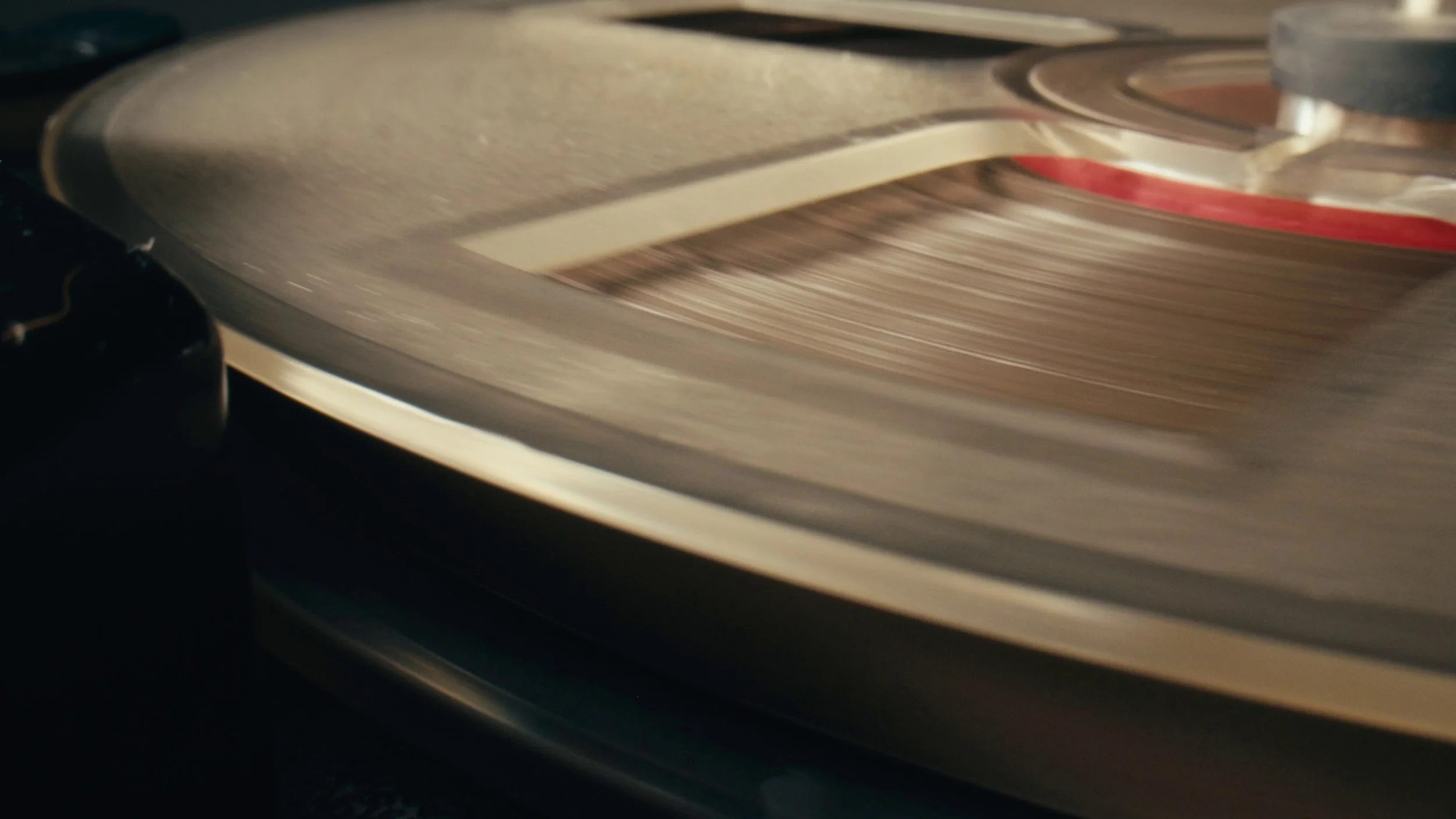 Close-up of a vinyl record spinning on a turntable with a red and white label.