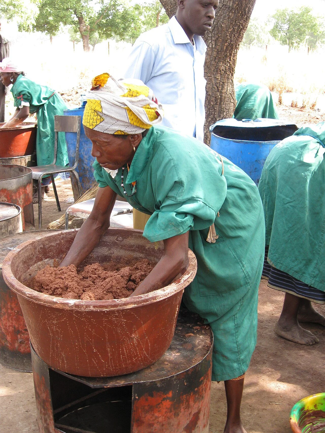 A woman of the ZaA woman of the Zantiébougou shea cooperative in Mali kneading shea butter by hand in a large basinntiébougou shea cooperative in Mali kneading shea butter by hand in a large basin
