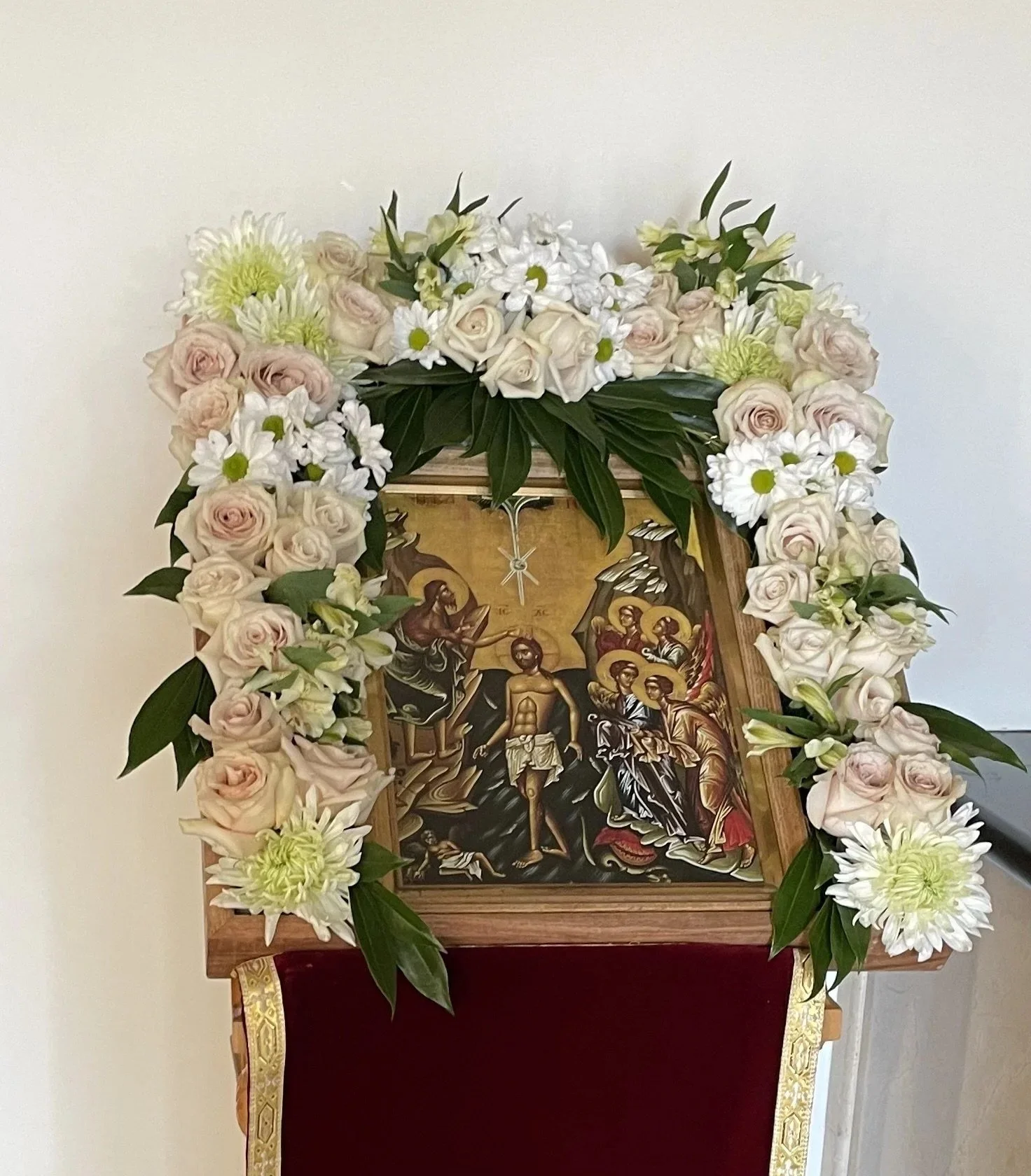 Feast icon framed with pale pink and white flowers
