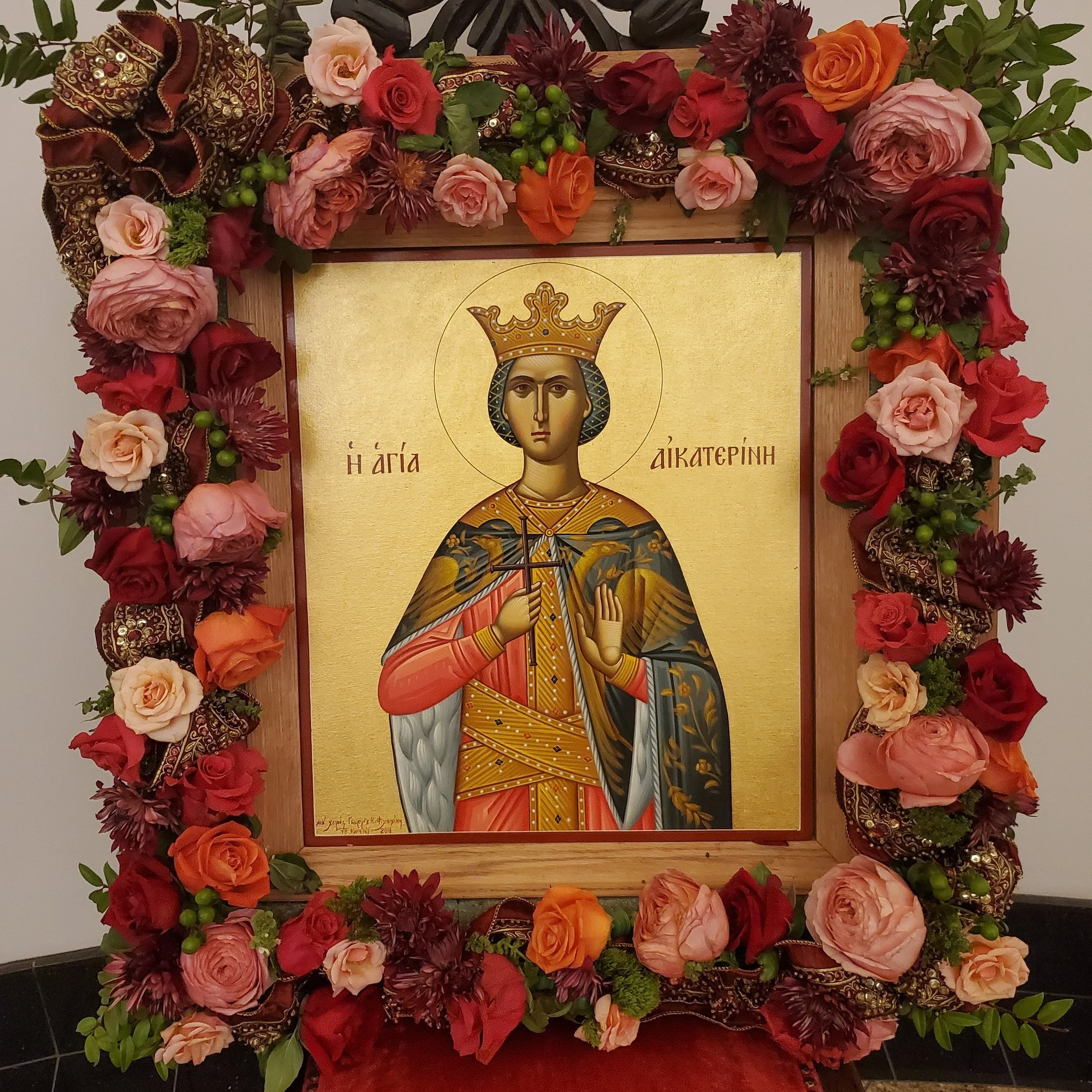 Icon of a crowned saint framed with red and pink roses