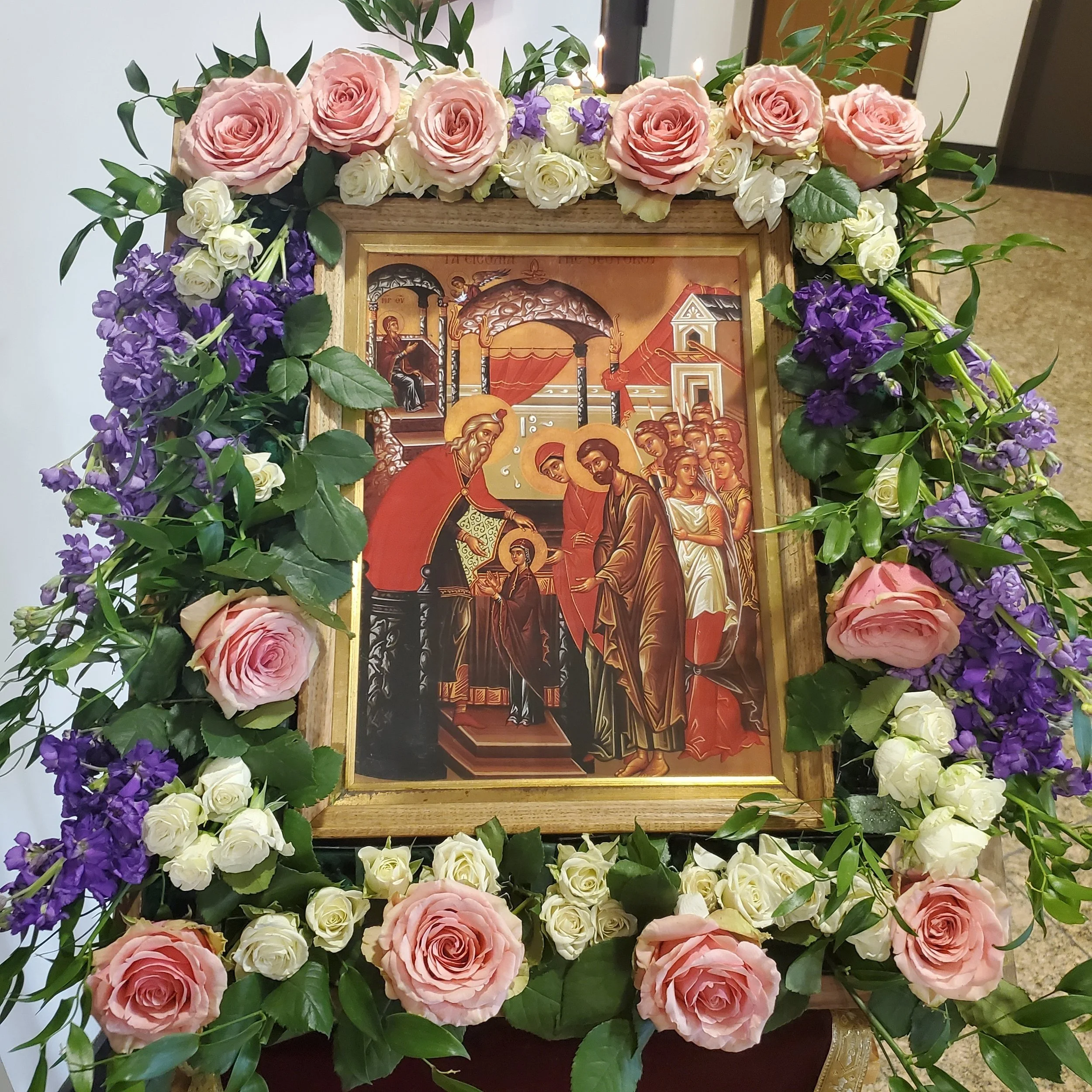 Feast icon framed with pink roses and purple flowers