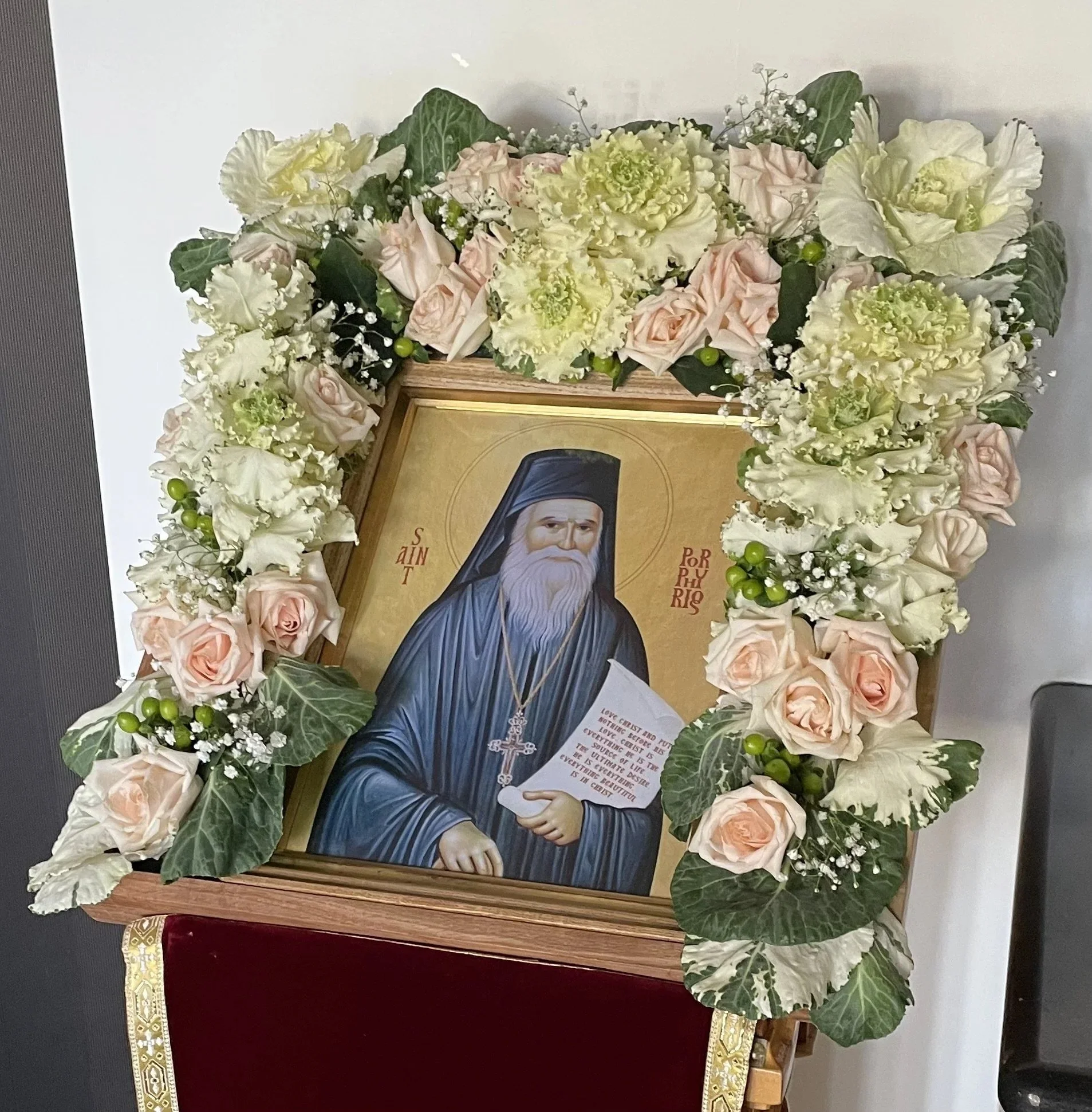 Icon of St. Porphyrios framed with pale pink and white flowers