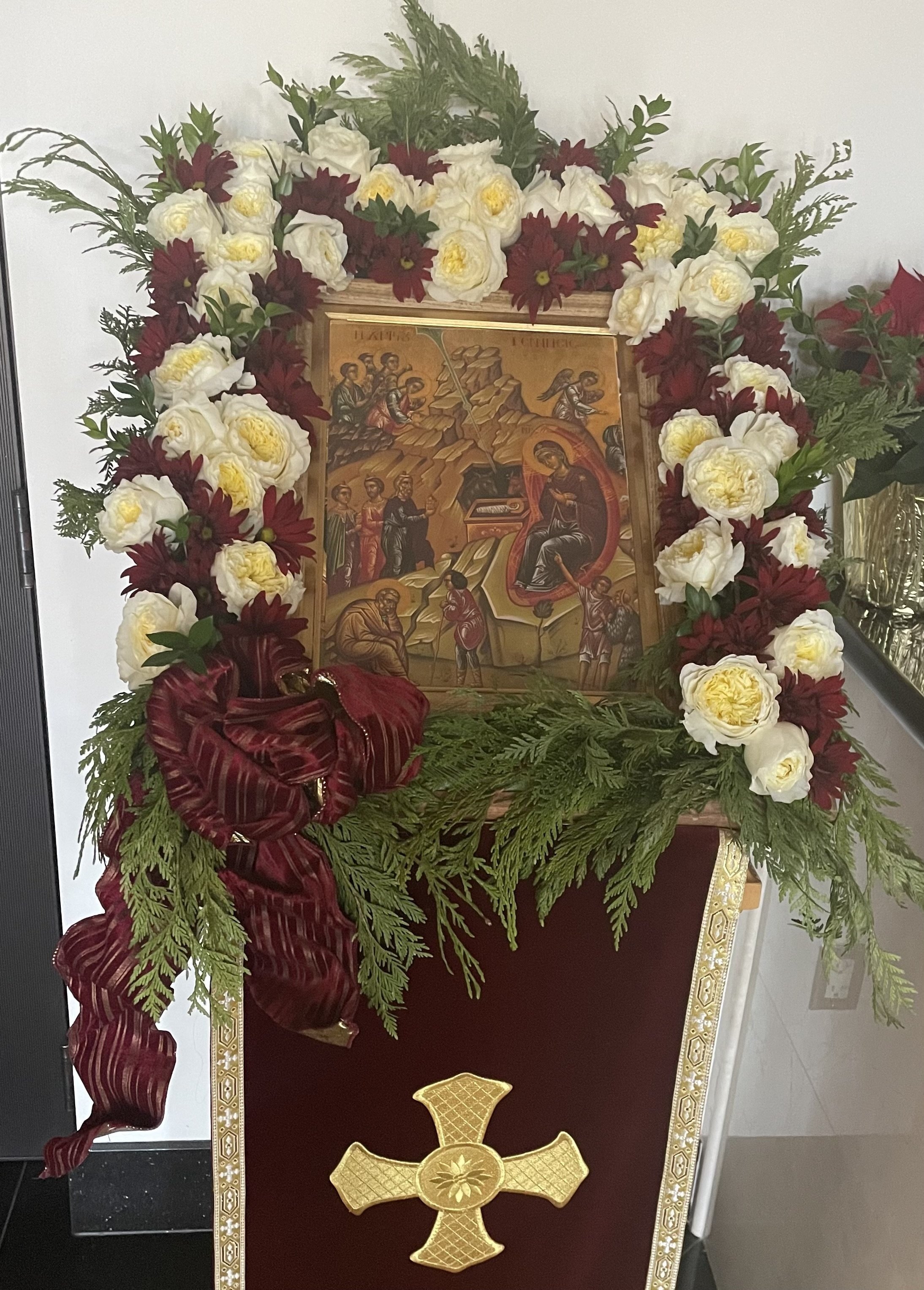 Feast icon framed with white and burgundy flowers
