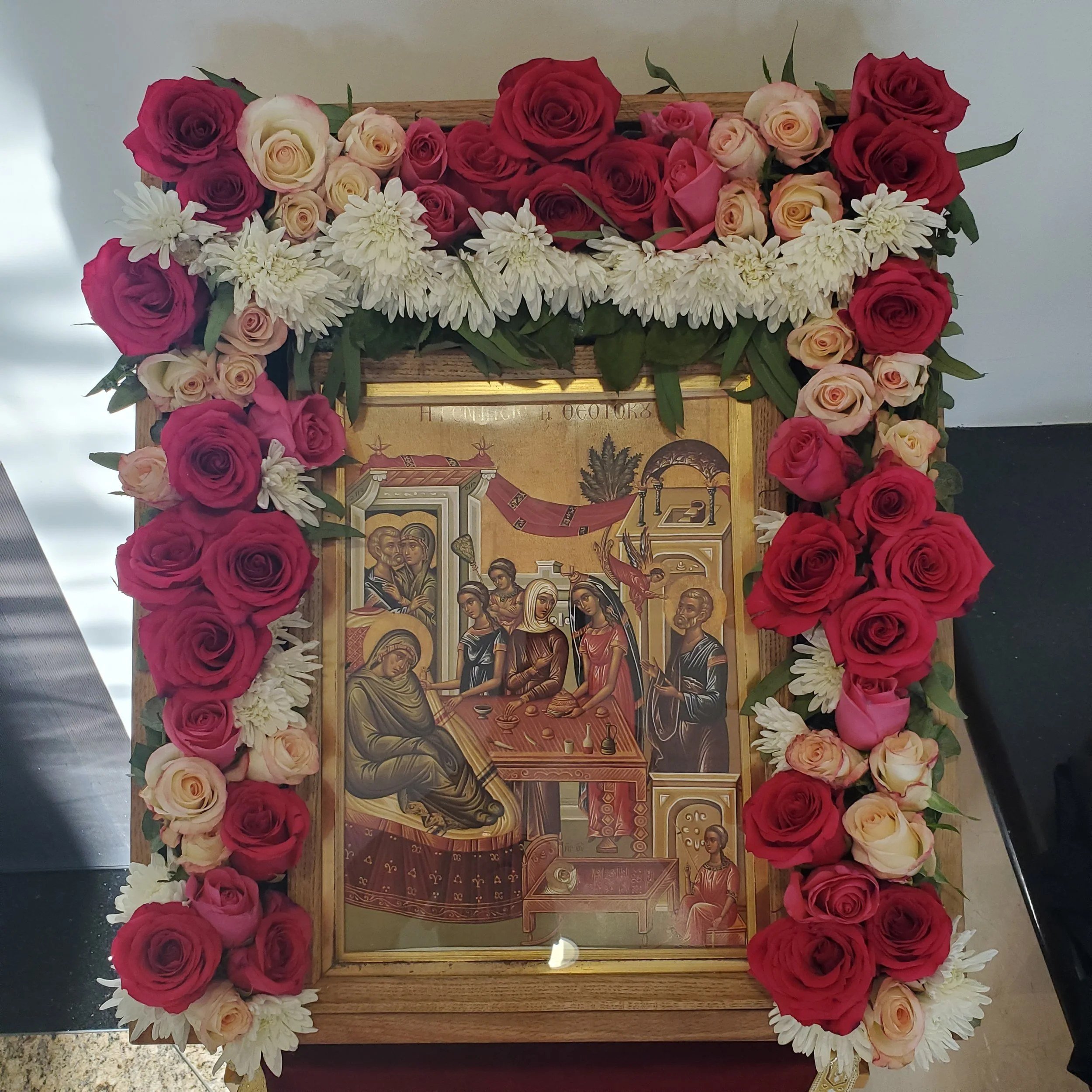 Feast icon framed with red and white roses