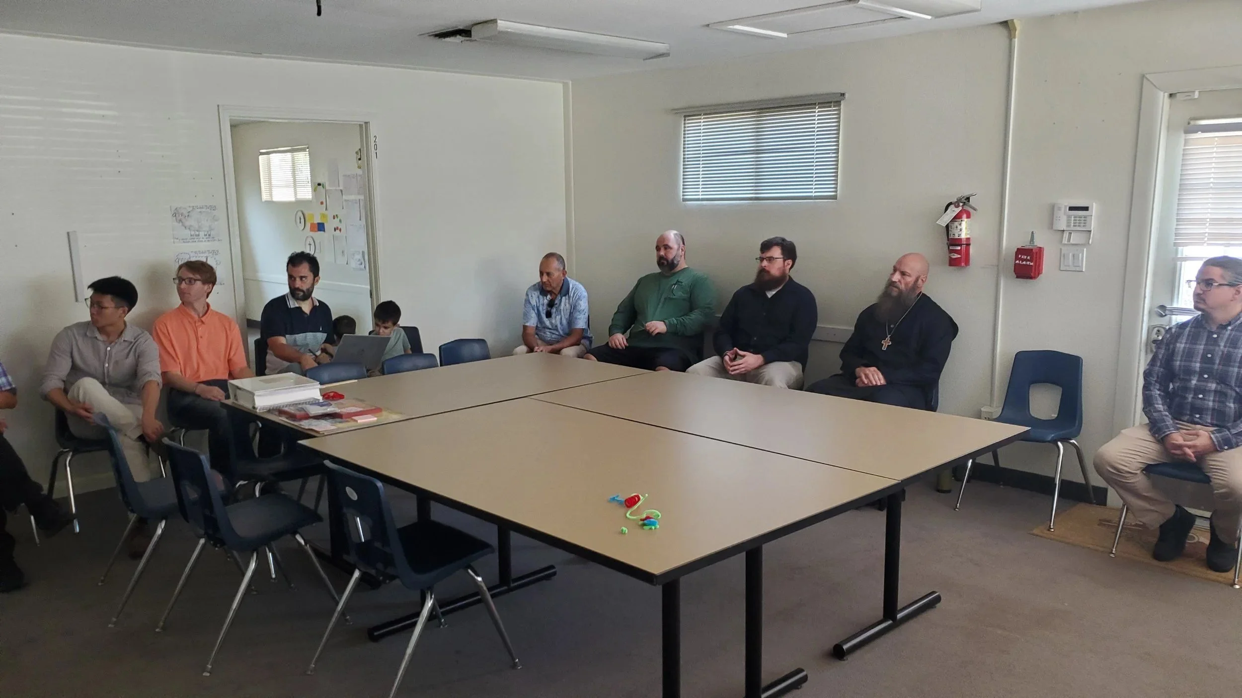 Men's Ministry members meeting around tables in a classroom