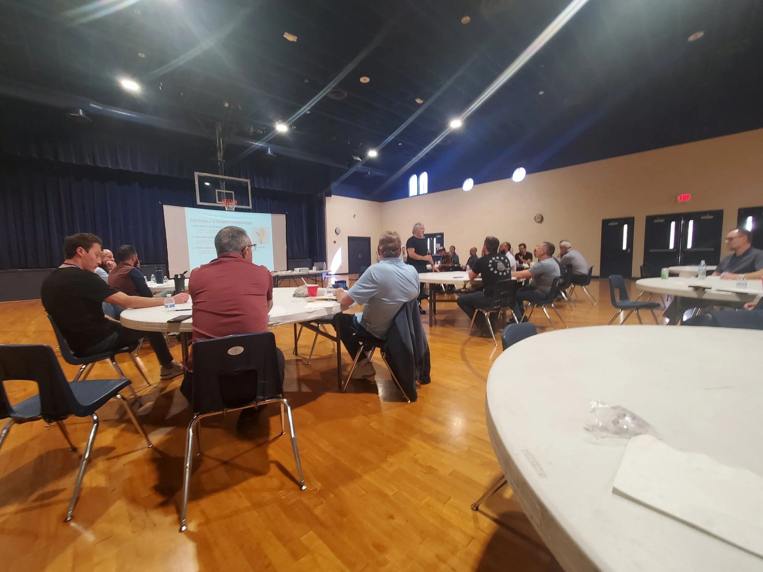 Men's Ministry members at round tables in the church hall