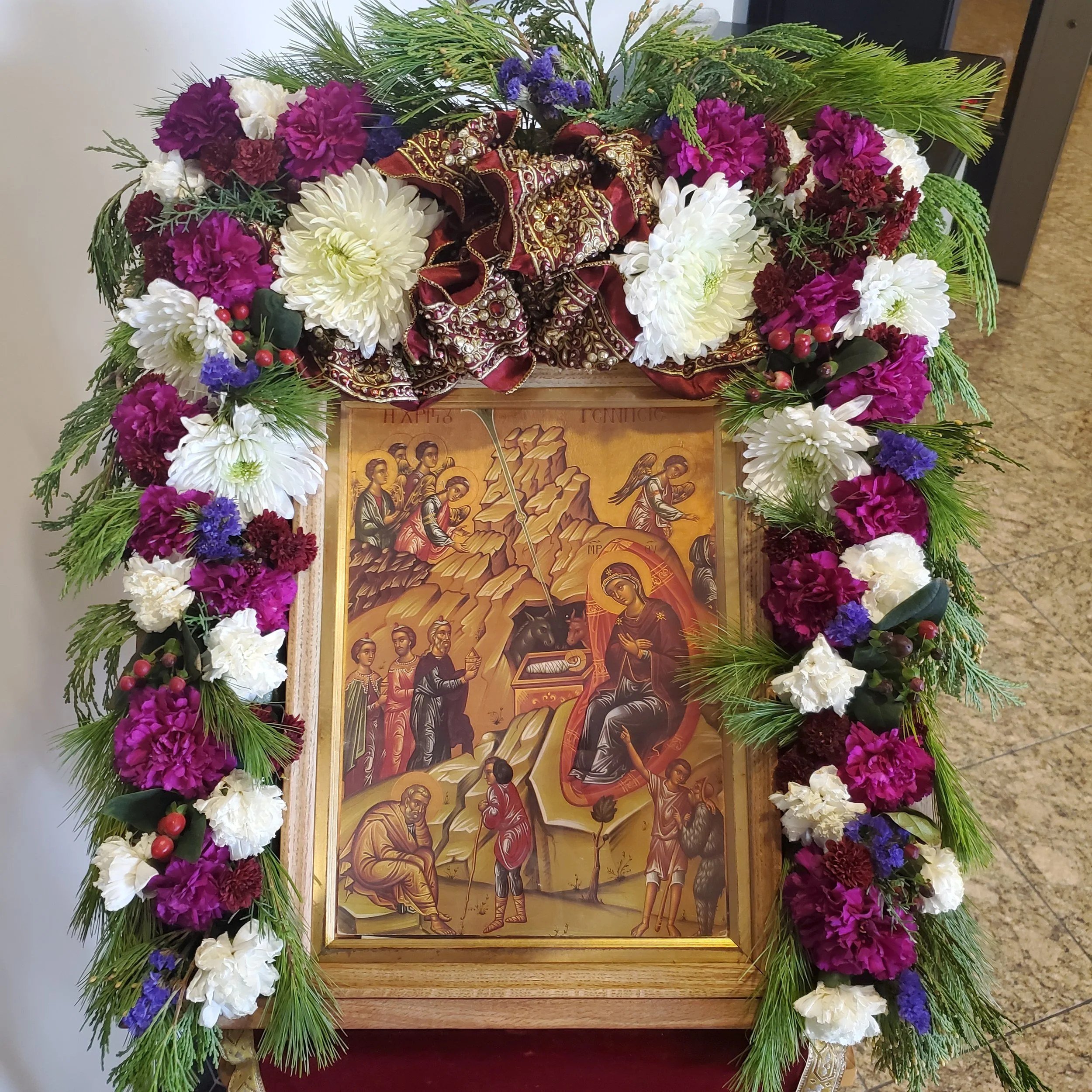 Nativity icon framed with white and purple flowers