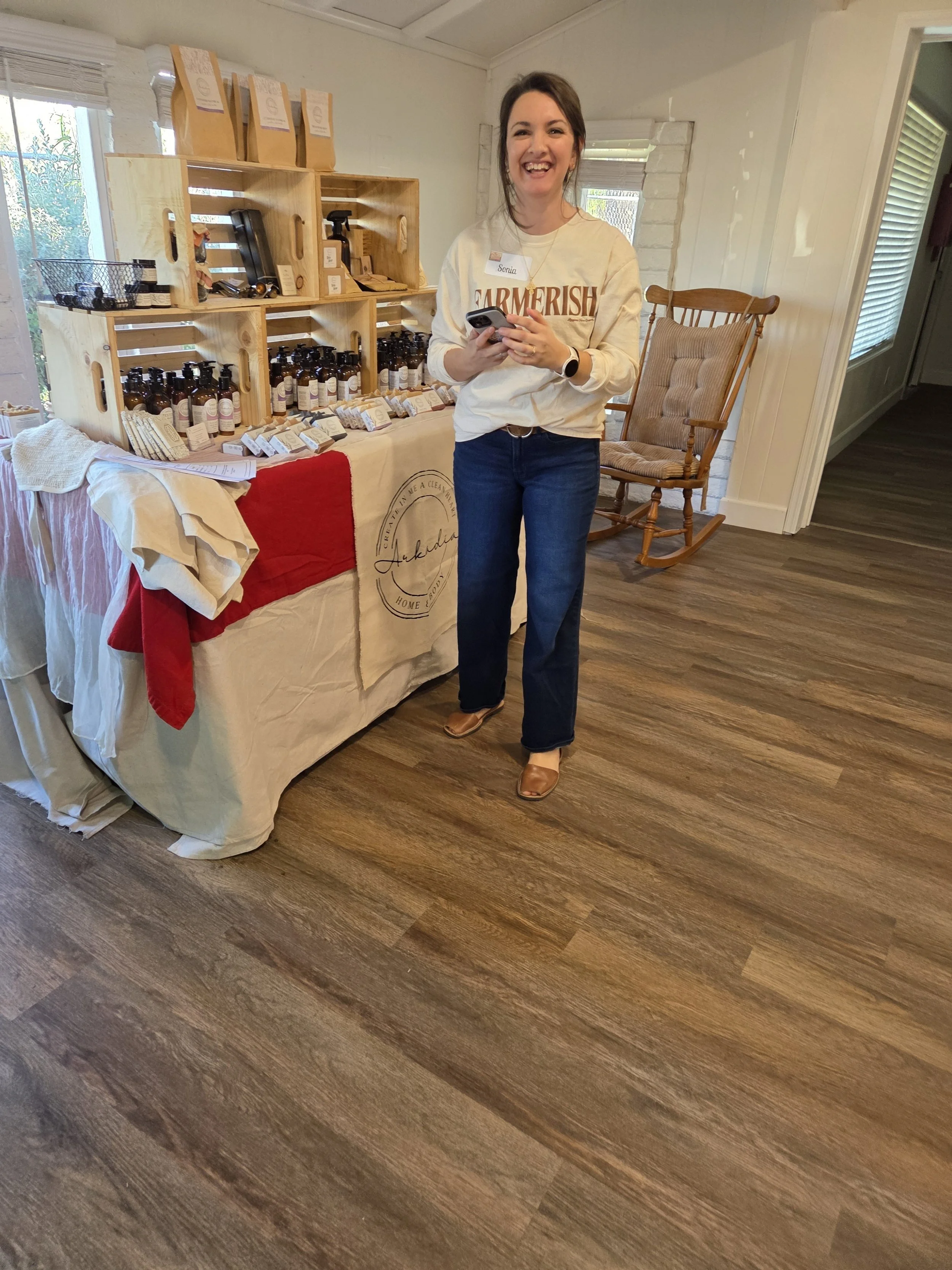 A Women's Ministry member beside a table of handmade goods