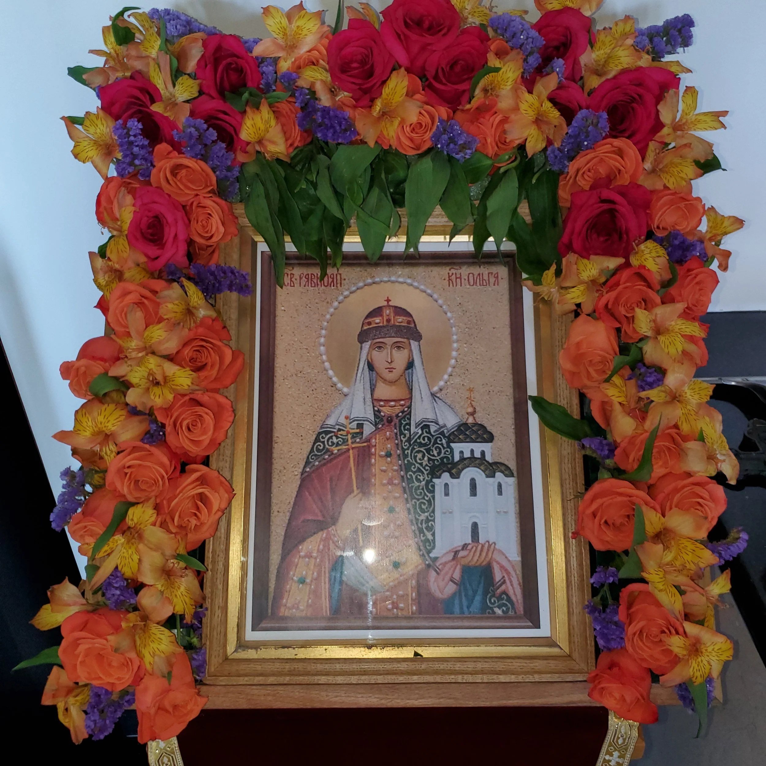 Icon of a crowned saint framed with orange, red and purple flowers