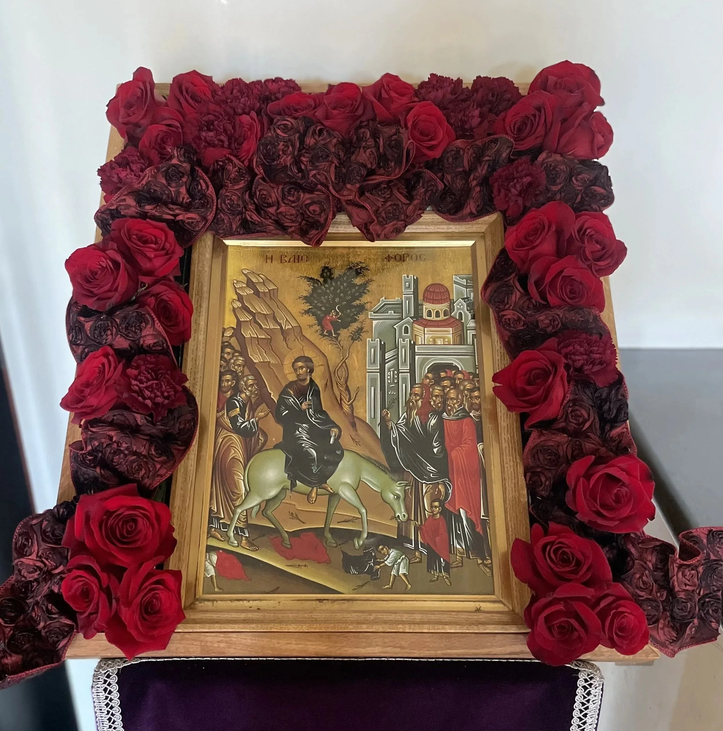 Feast icon framed with deep red roses