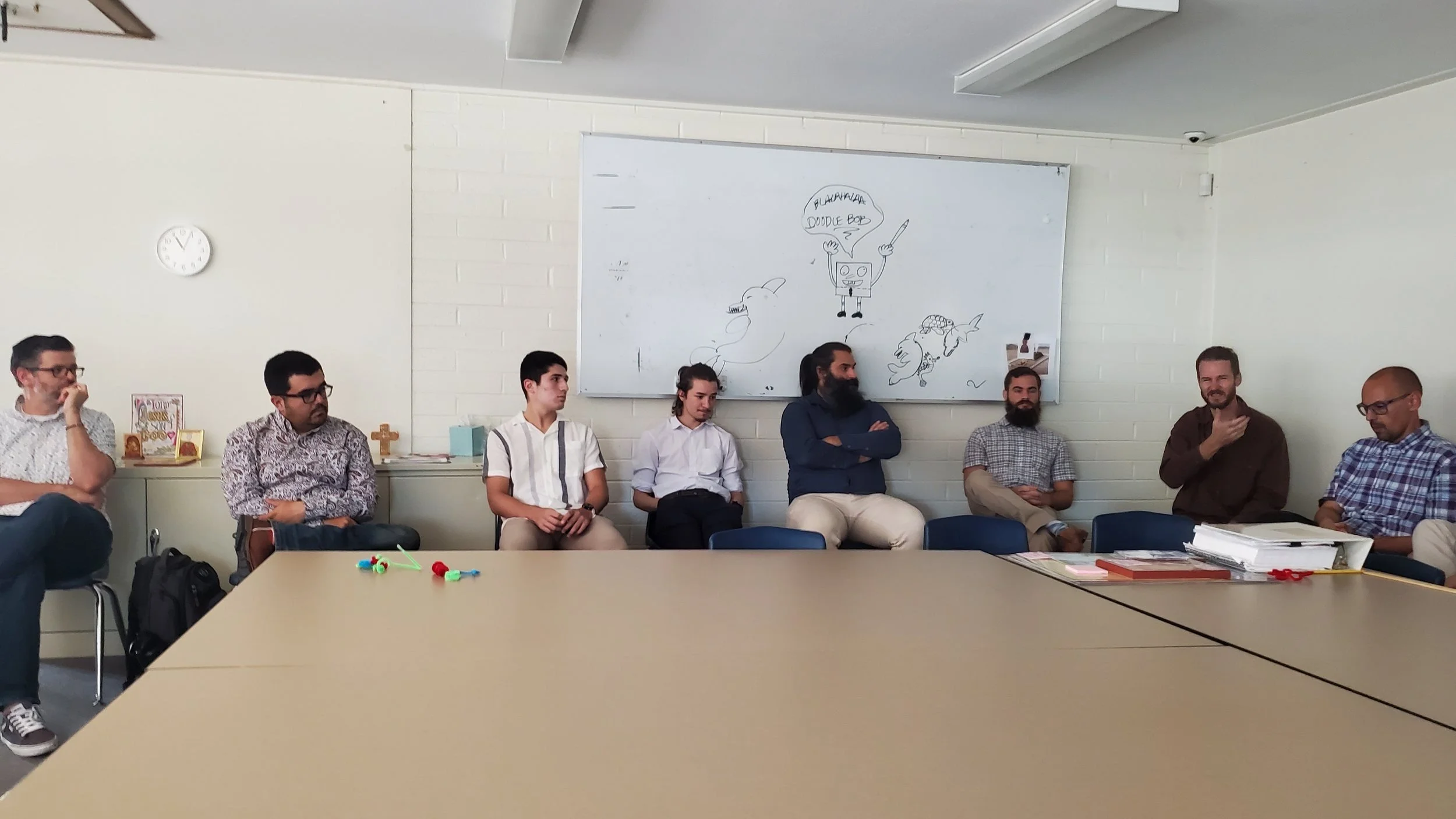 Men's Ministry members meeting around tables in a classroom
