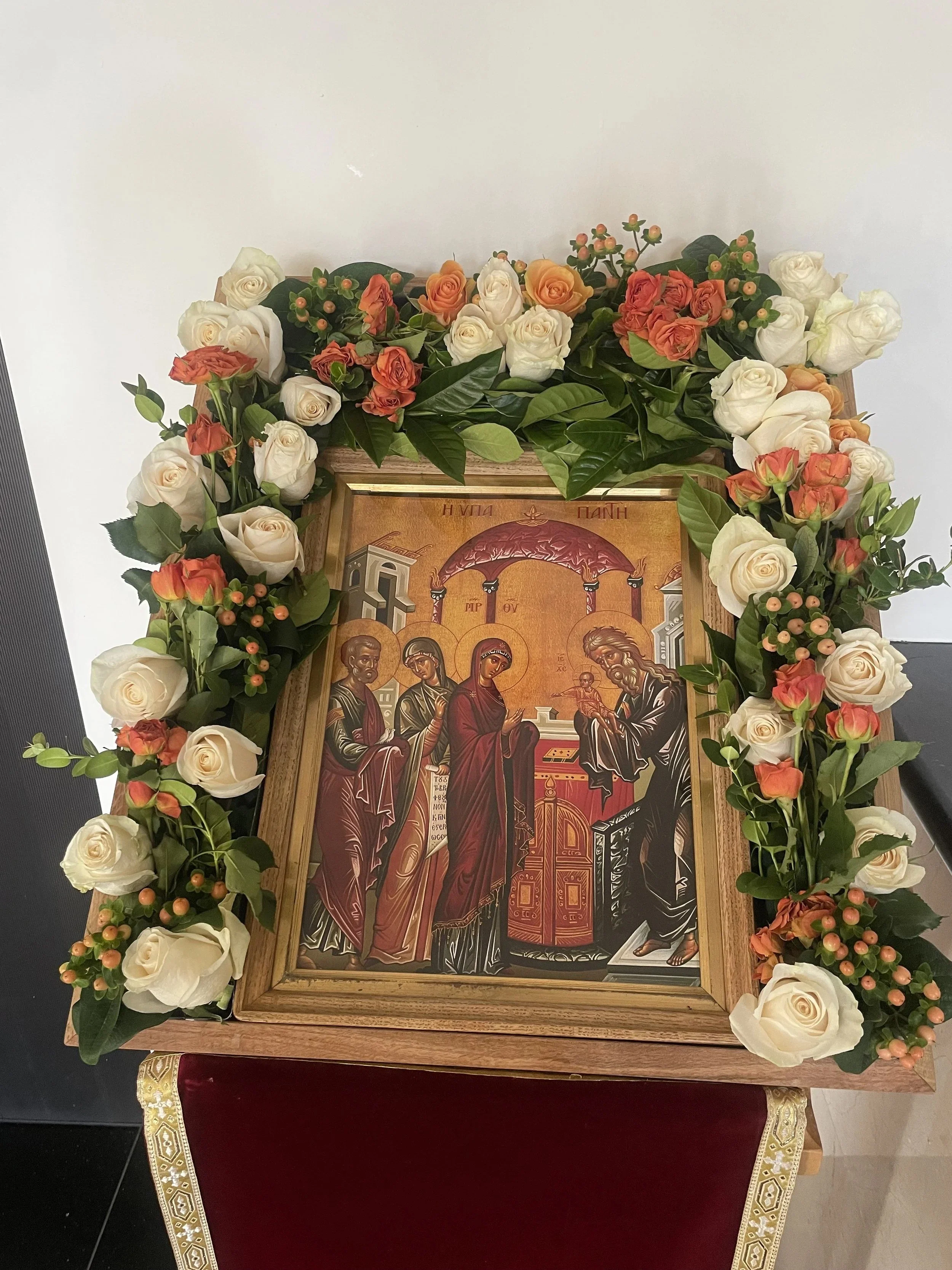 Feast icon framed with white, peach and orange flowers