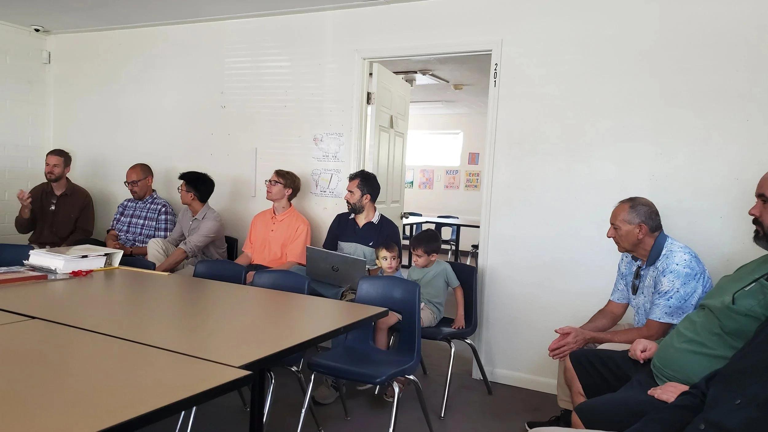 Men's Ministry members meeting around tables in a classroom