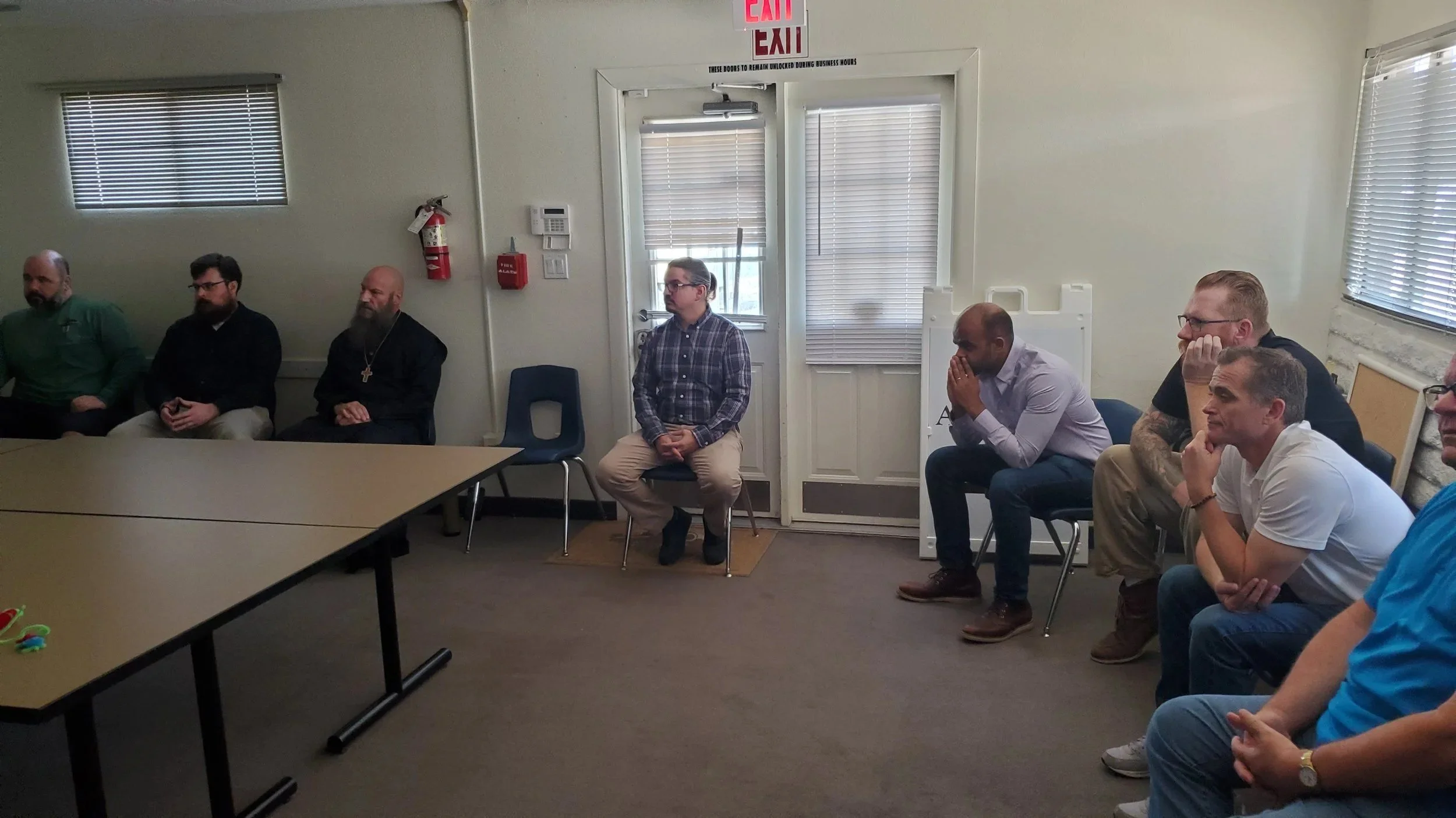 Men's Ministry members meeting around tables in a classroom