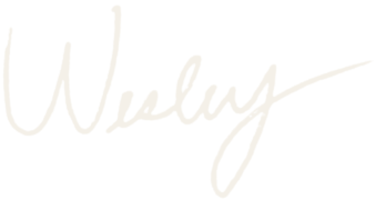 White handwritten signature reading 'Wesley' on a black background.