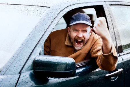 angry road rage driver yelling with fist shaking