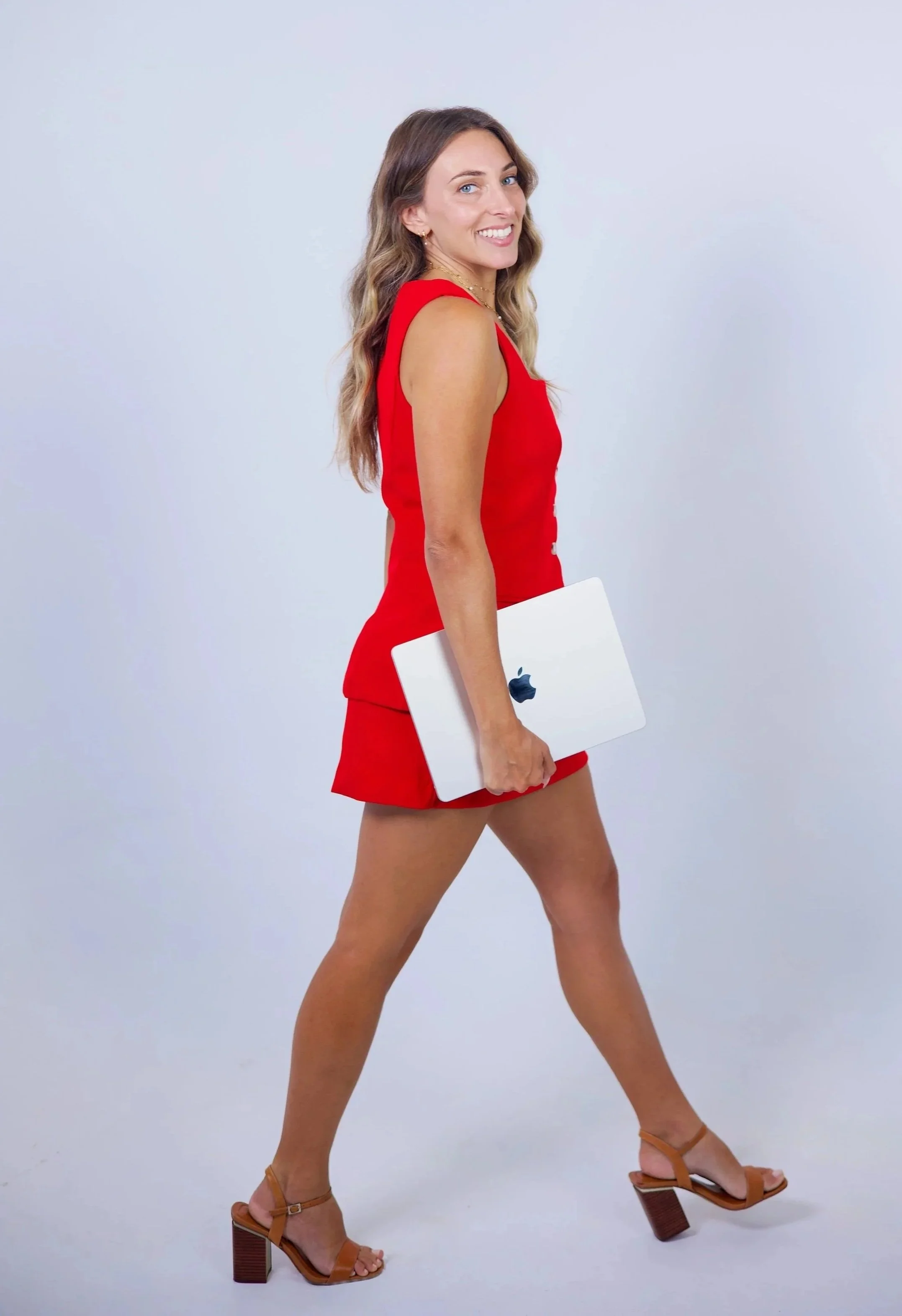 Founder Hannah Kavy smiling and walking while carrying an Apple laptop