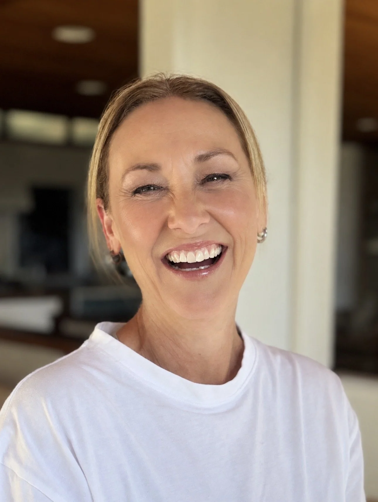 Smiling woman in a white shirt posing indoors