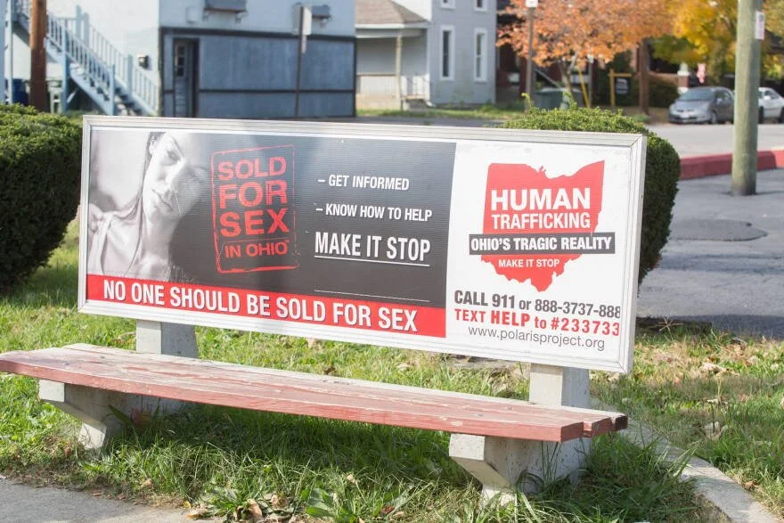 A sign on a lawn promoting awareness against sex trafficking in Ohio, highlighting that no one should be sold for sex, with a phone number and website for help.