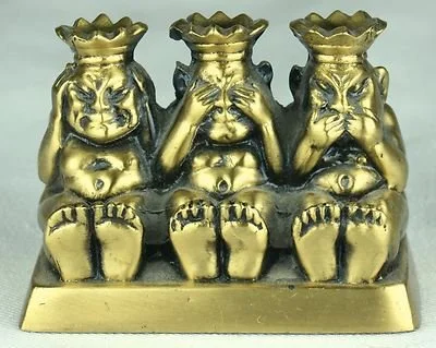 Three monkey statues with crowns, each one covering different eyes, ears, and mouth, representing "see no evil," "hear no evil," and "speak no evil."